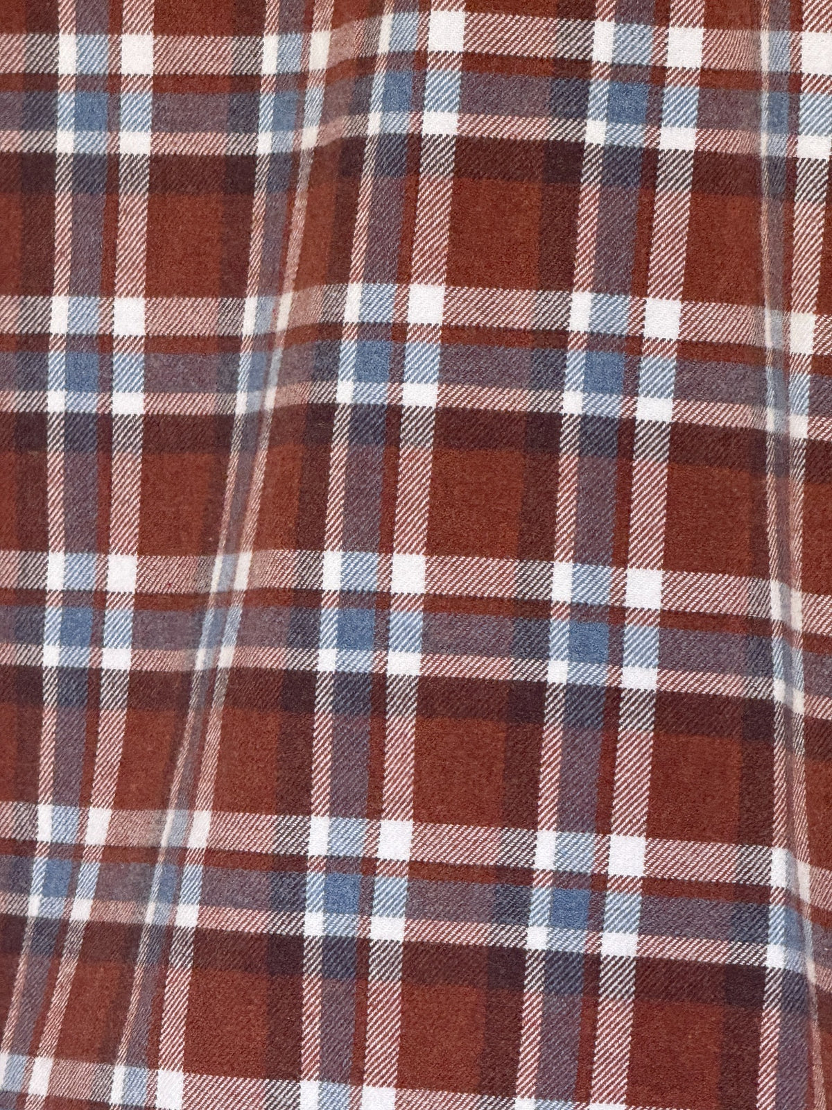 Vintage plaid flannel shirt brown blue white fabric close-up