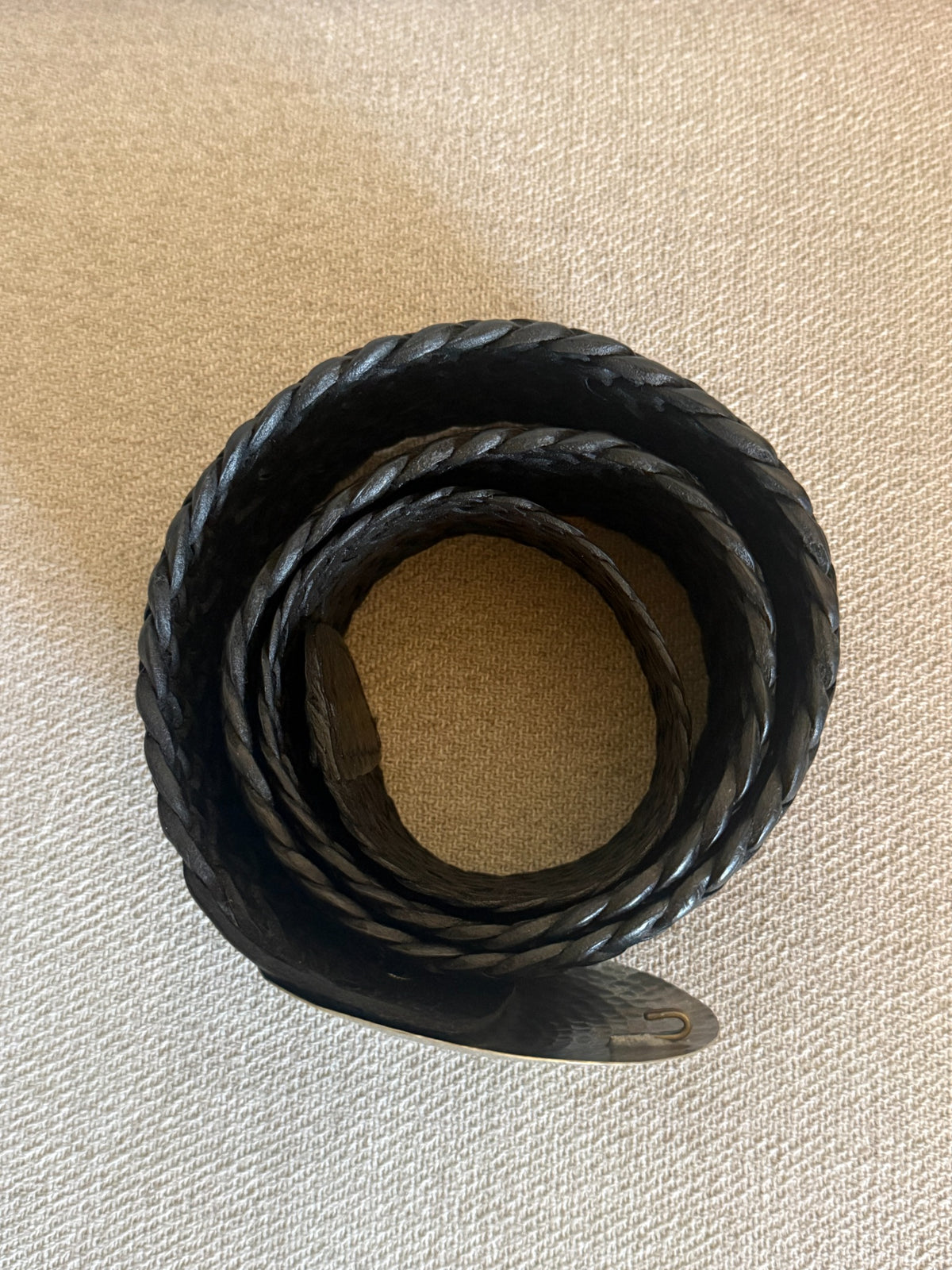 Black braided leather belt and oversized round hammered silver-tone buckle