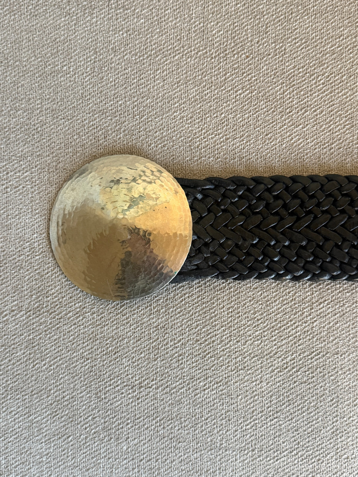 Black braided leather belt and oversized round hammered silver-tone buckle