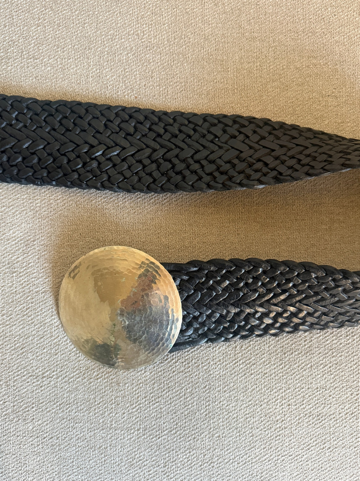 Black braided leather belt and oversized round hammered silver-tone buckle