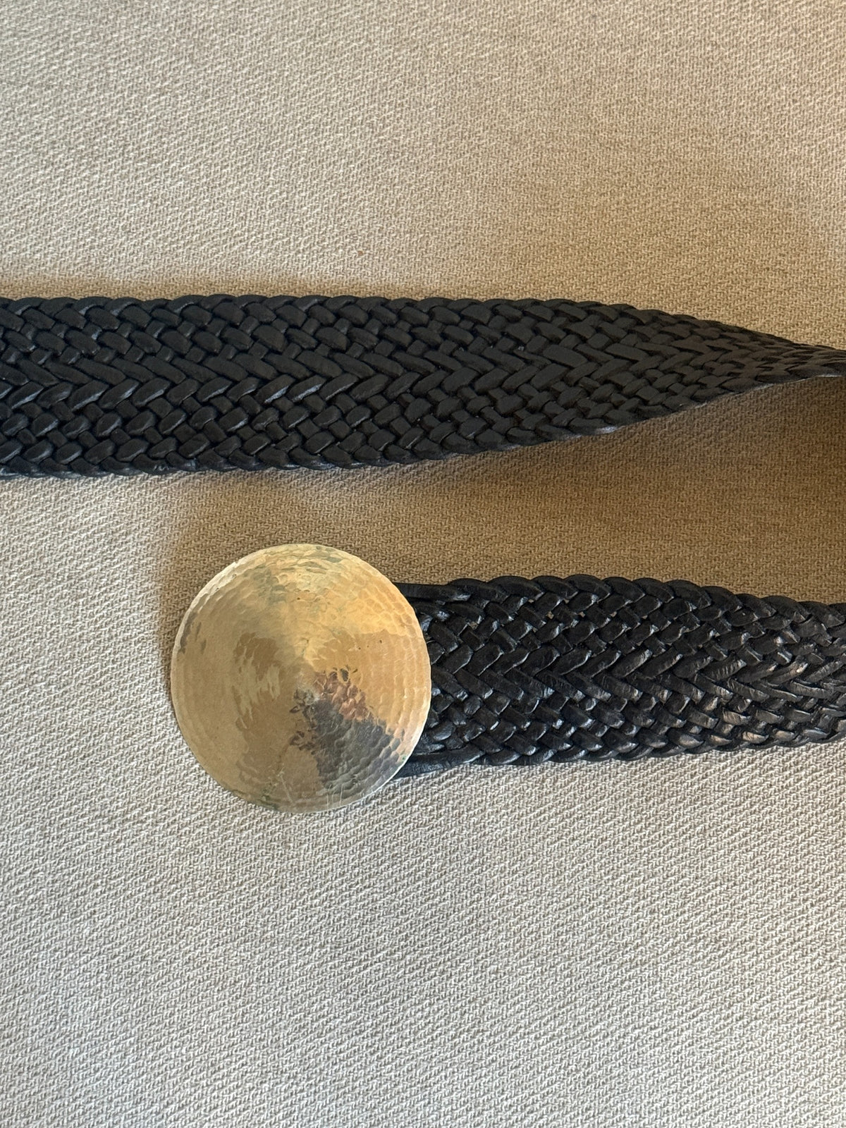 Black braided leather belt and oversized round hammered silver-tone buckle