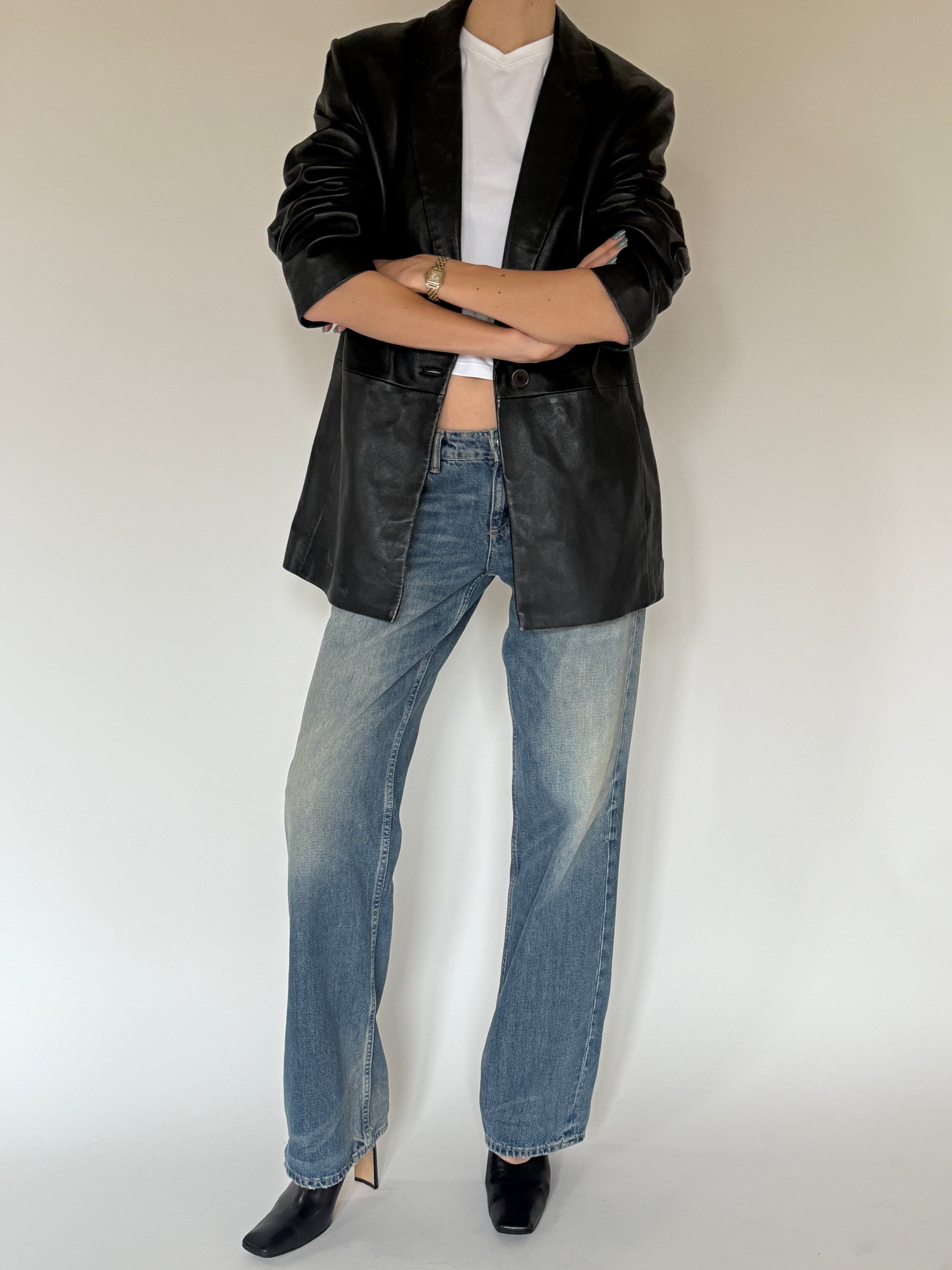 Vintage black leather blazer angled view with classic silhouette