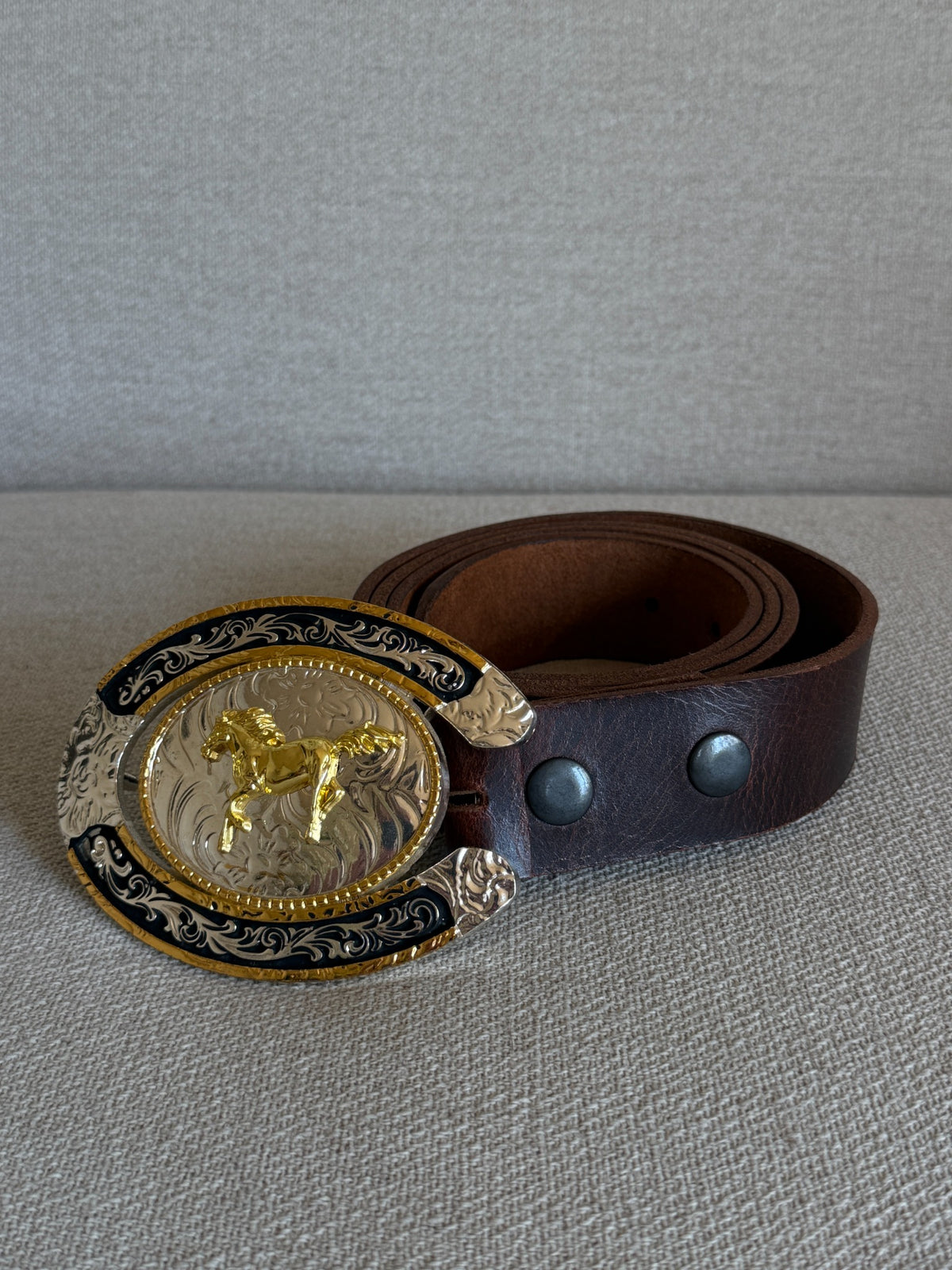 Vintage western leather belt with ornate horseshoe horse buckle front view