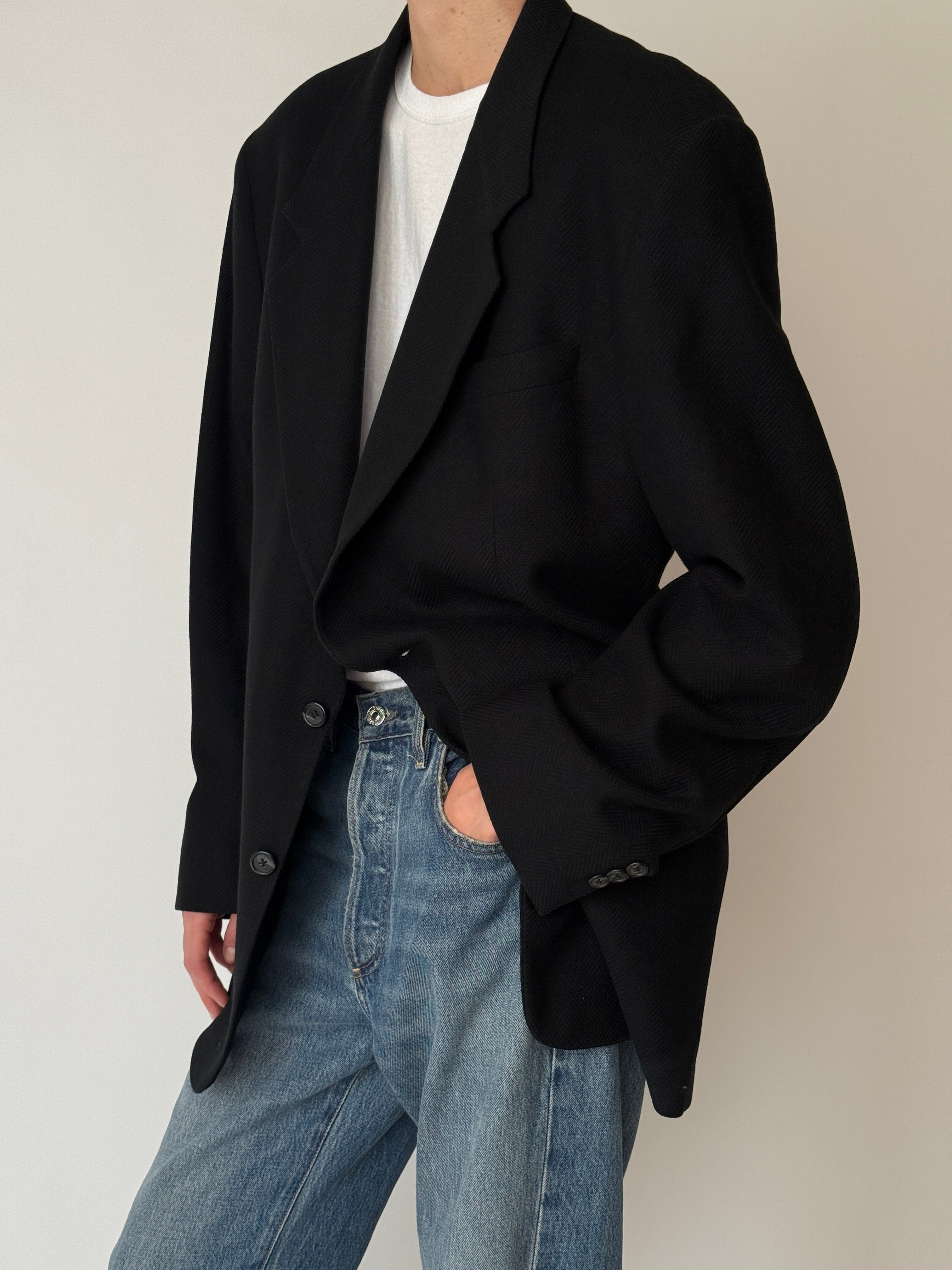 Vintage black wool blazer with relaxed silhouette and flap pockets