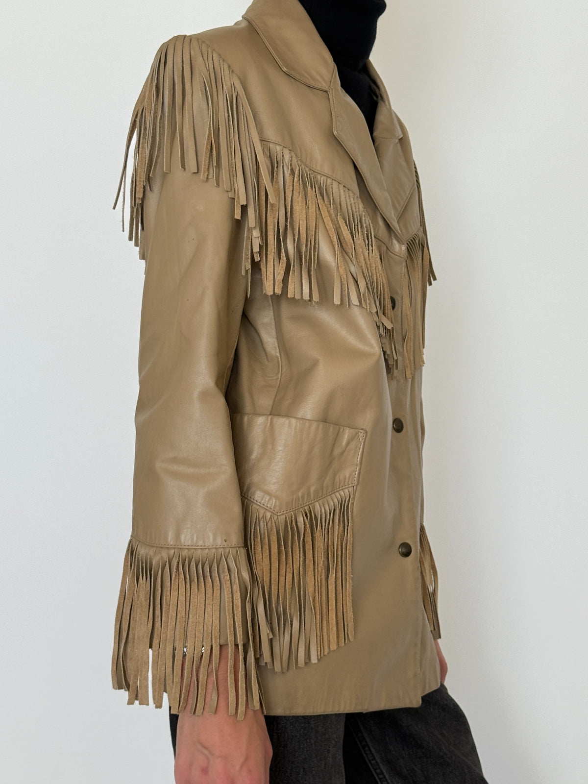 Side view of vintage tan leather jacket showing fringe