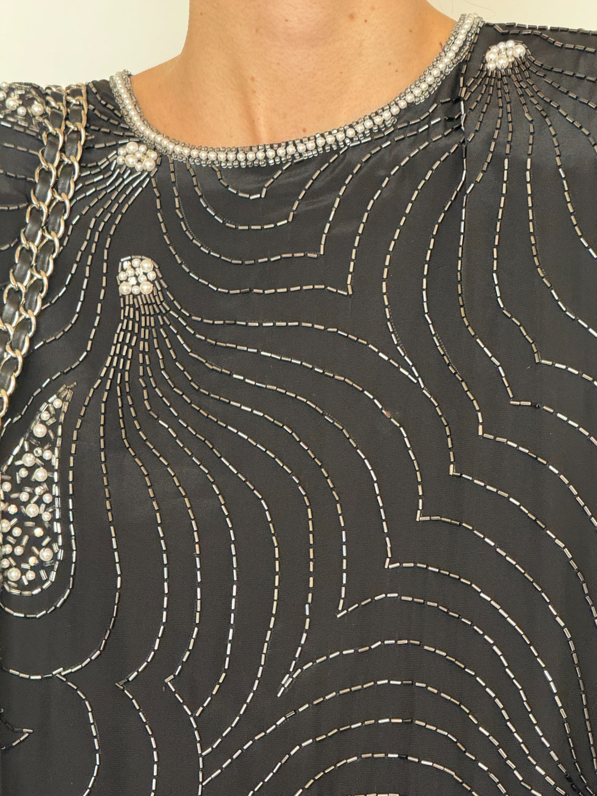 Close-up of swirling silver bugle bead embellishment