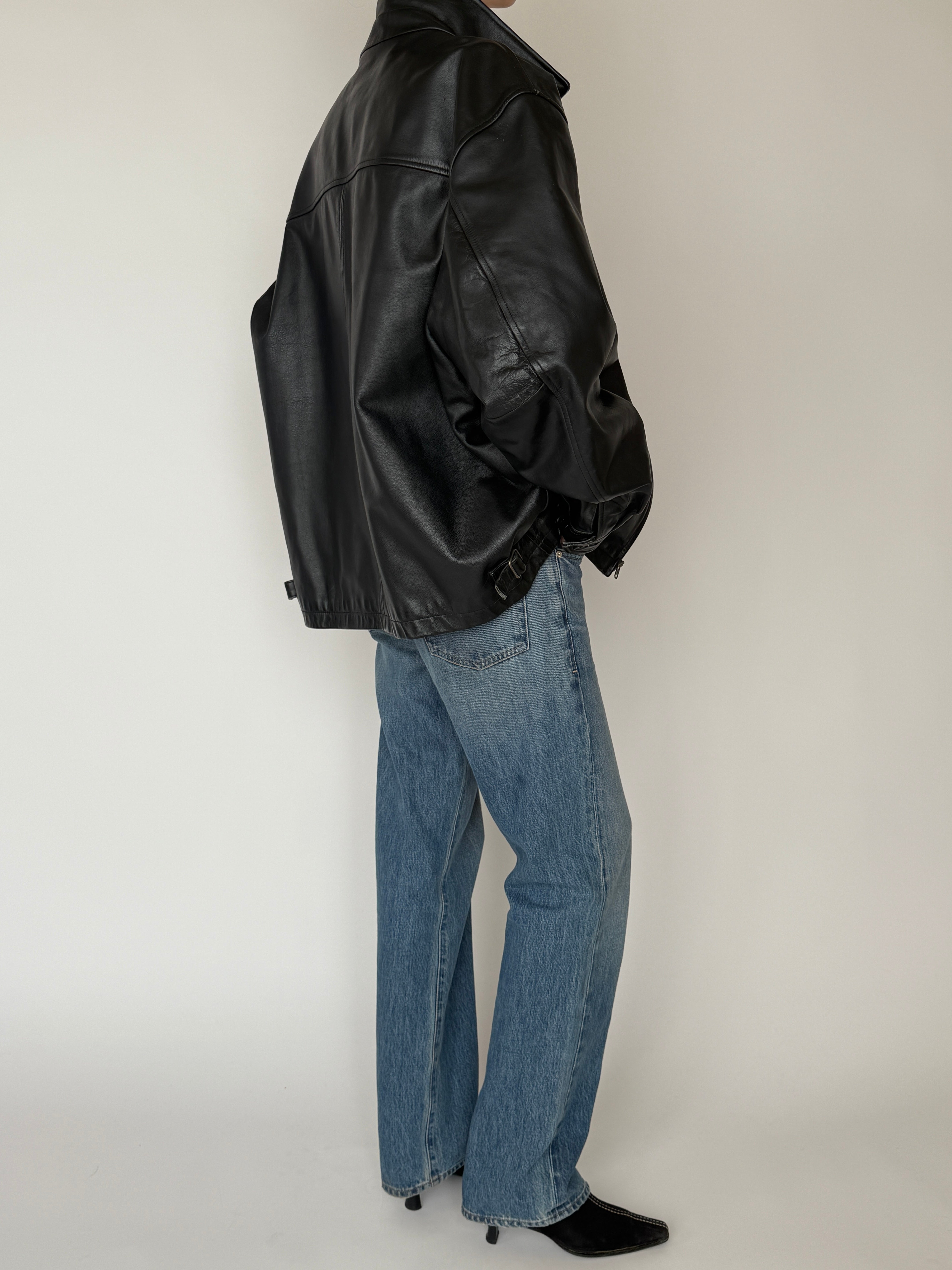 Vintage leather jacket with full-length zipper and soft leather texture in black back view