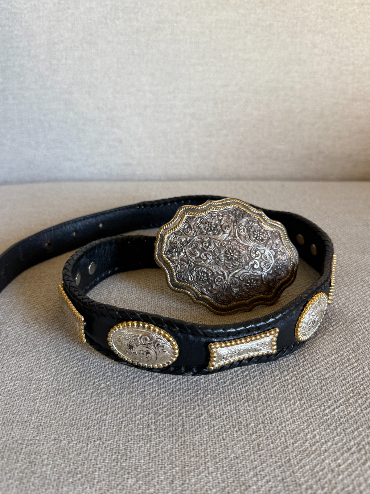 Vintage black leather western concho belt with ornate engraved buckle front view