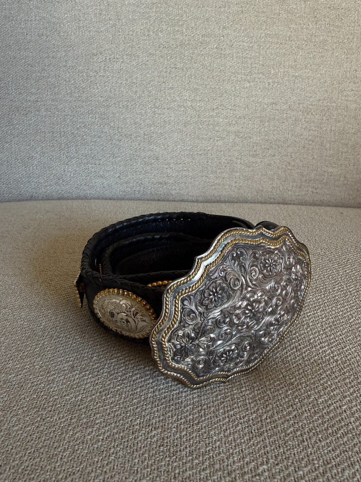 Angled view of floral engraved silver and gold tone buckle