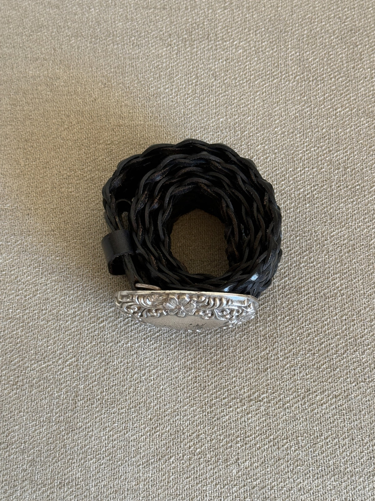 Rolled side view of black braided leather belt