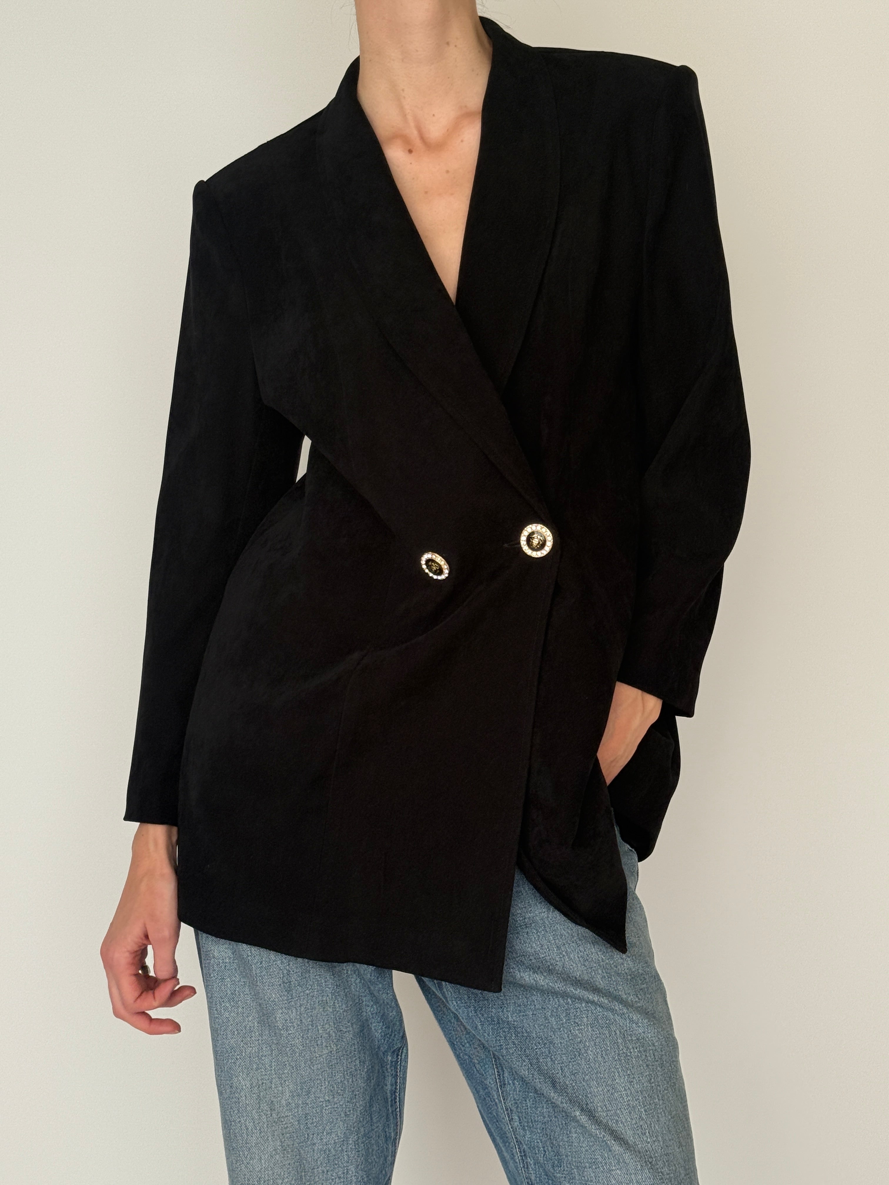 Vintage black blazer close-up showing decorative gold-tone buttons