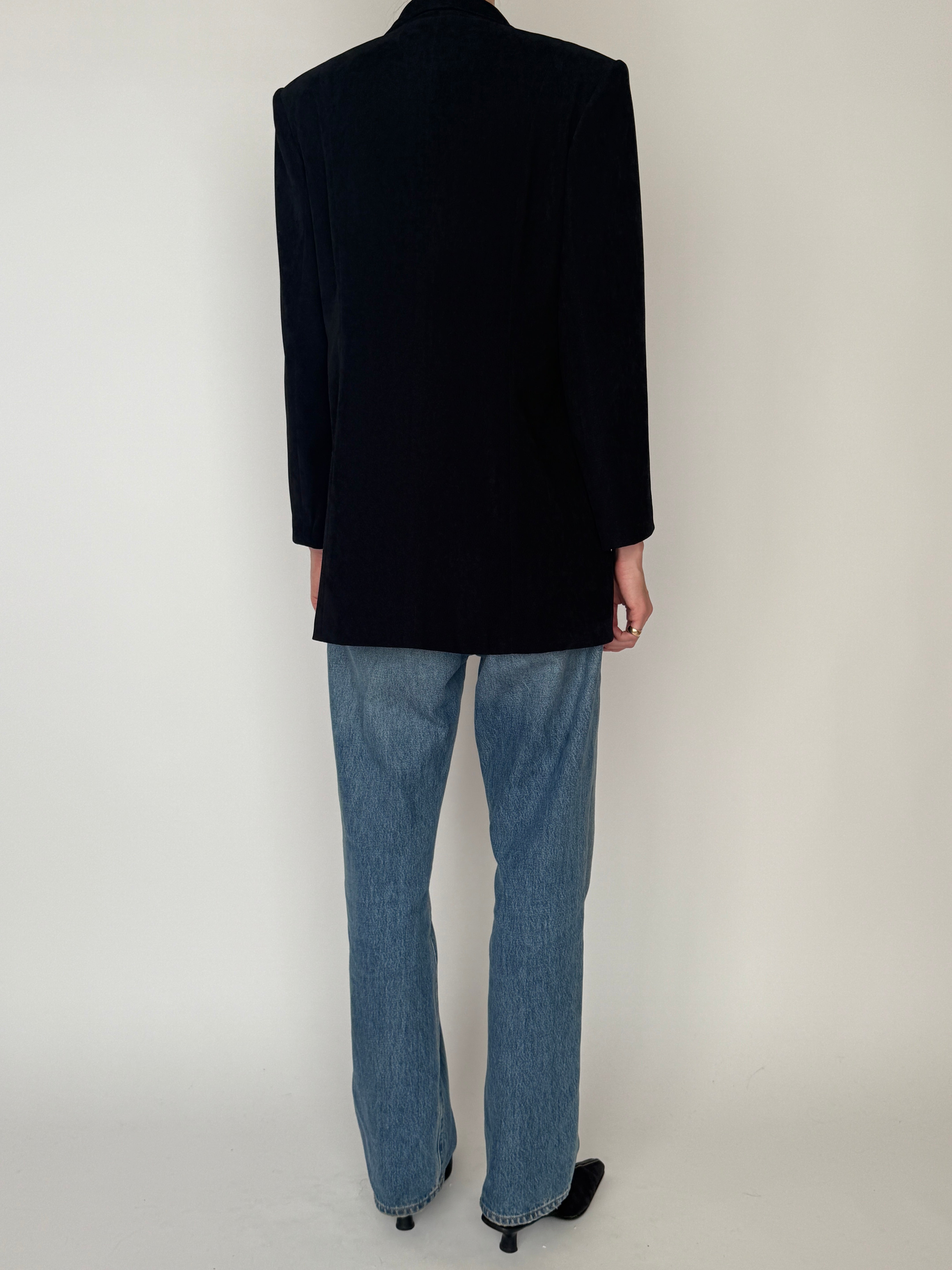 Vintage black blazer close-up showing decorative gold-tone buttons back view