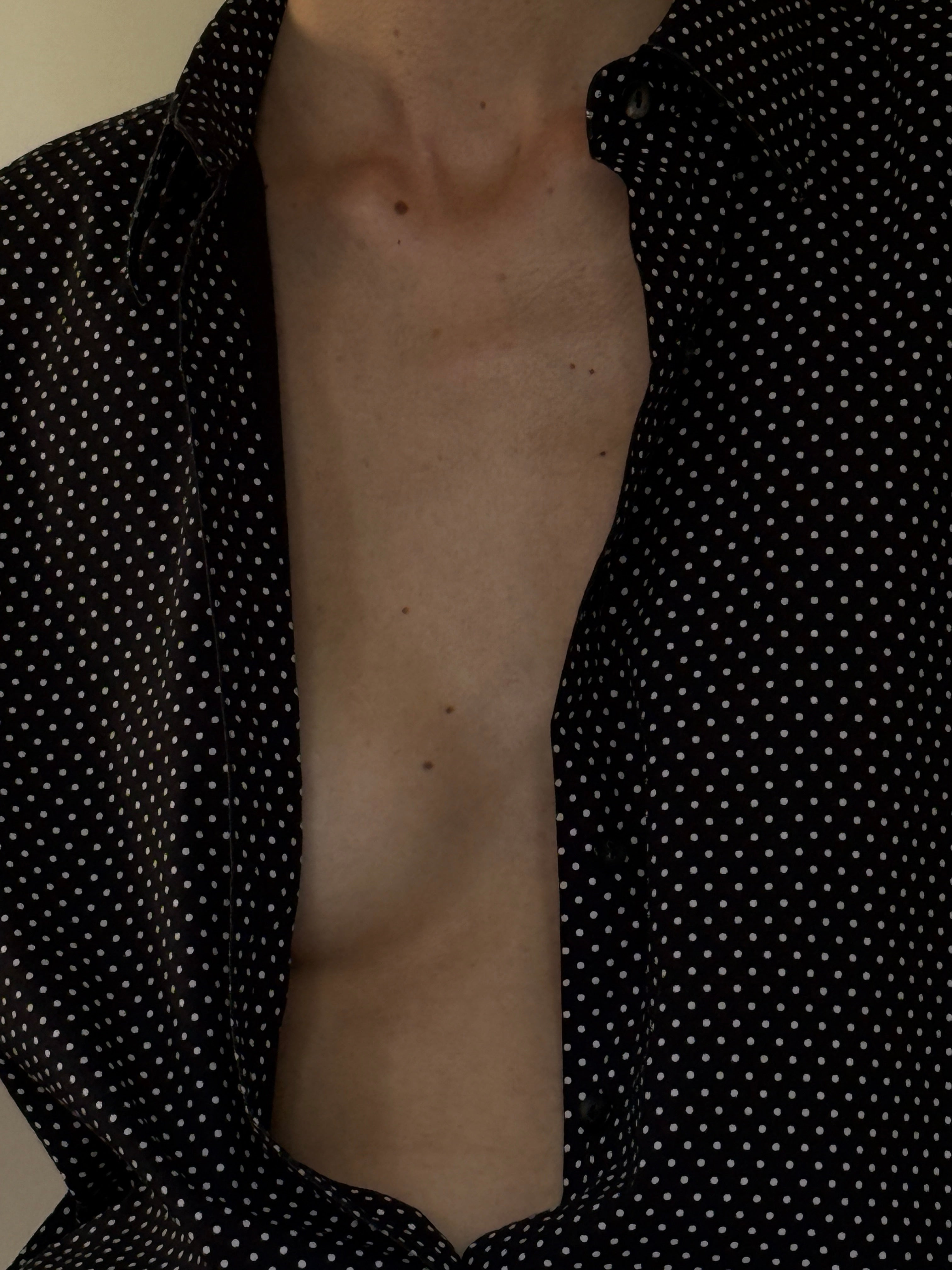Vintage black shirt fabric close-up with white polka dots