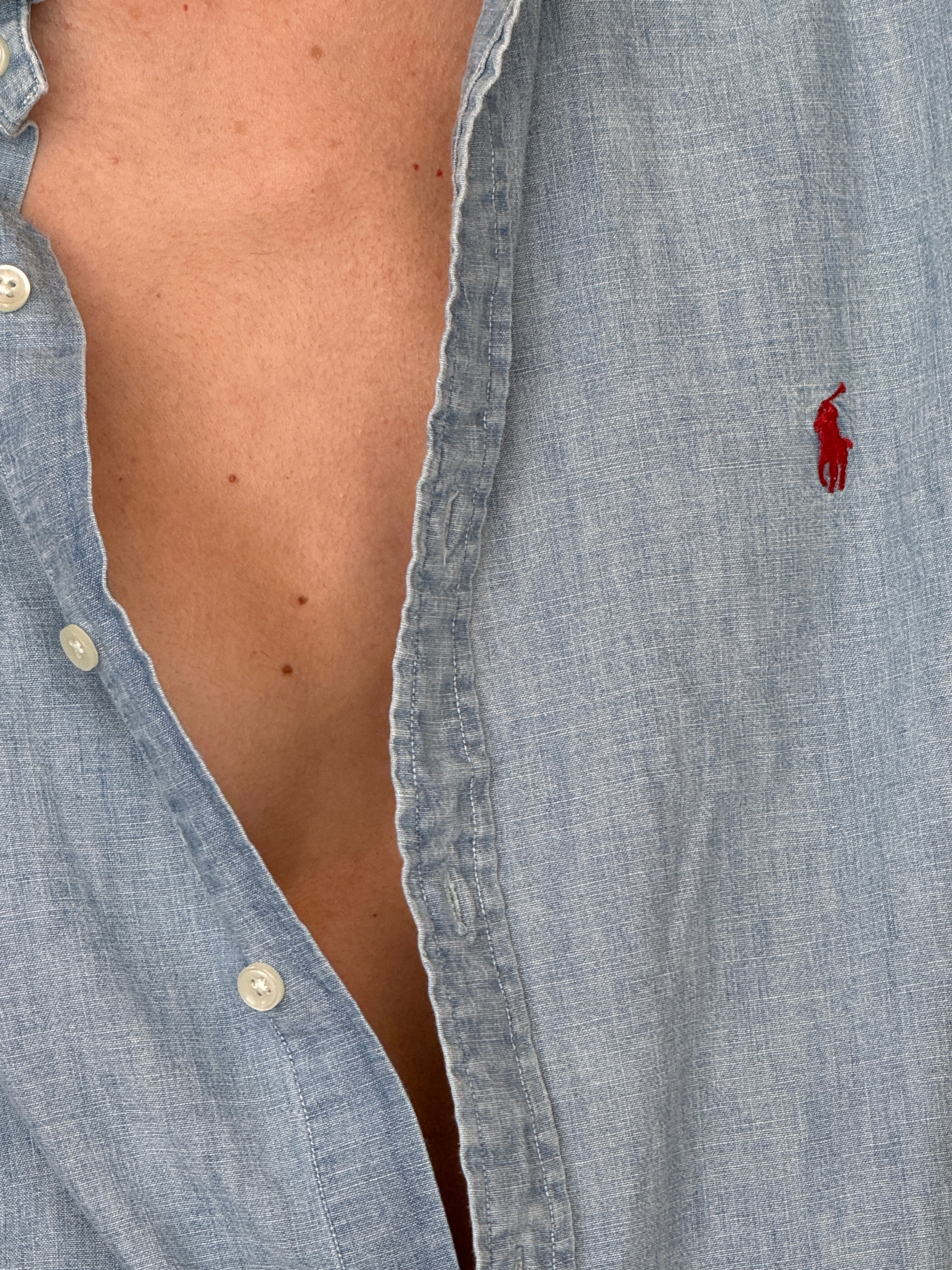 Vintage Ralph Lauren shirt close-up showing red polo logo on light blue fabric
