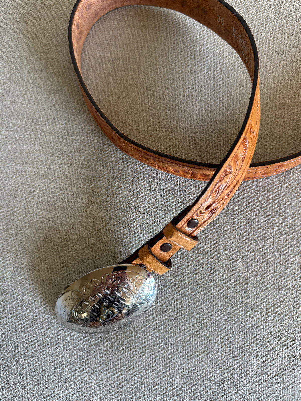 Vintage Western tooled leather belt curved view tan