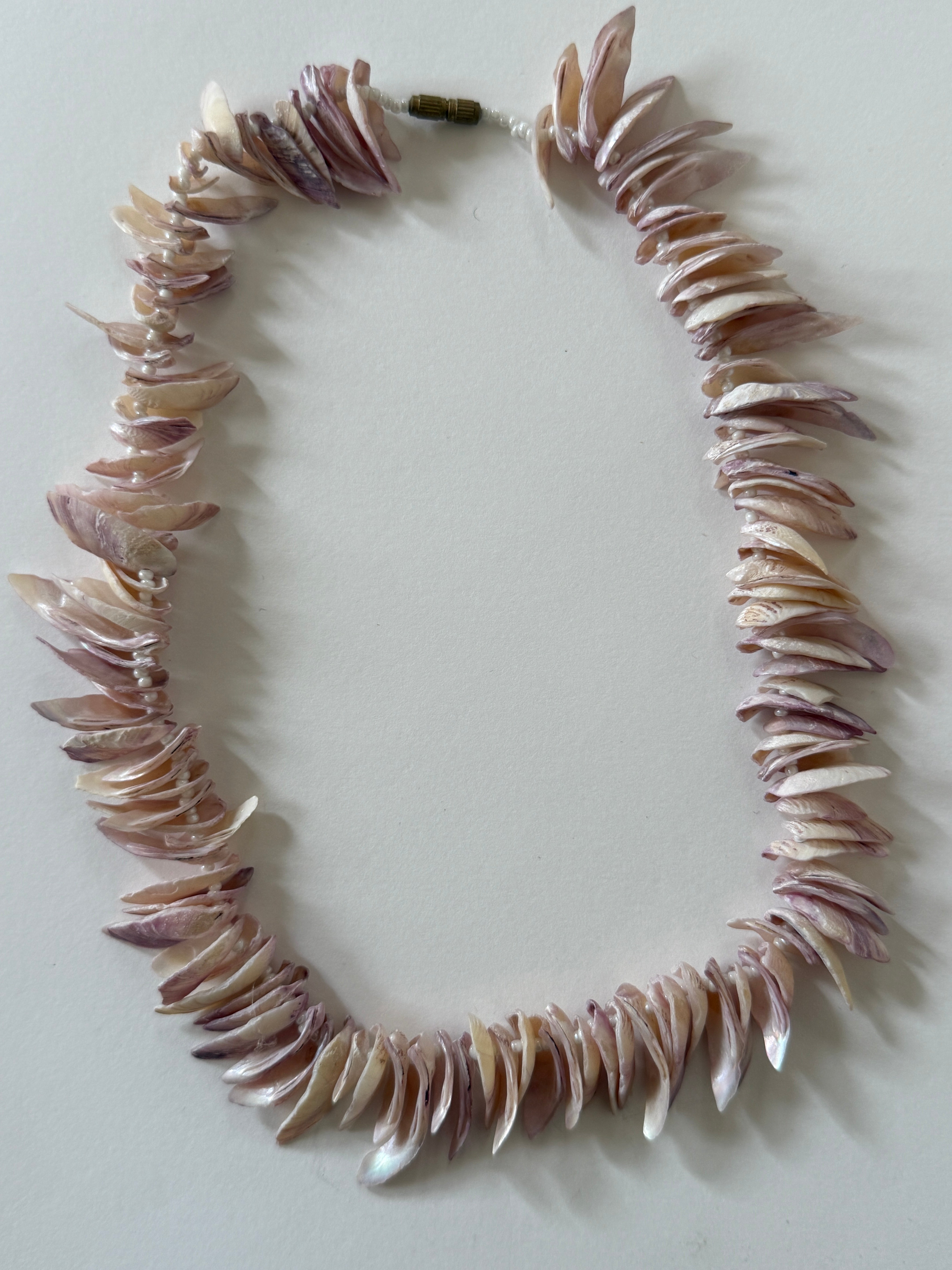 Vintage pink shell chip necklace angled side view showing strand texture