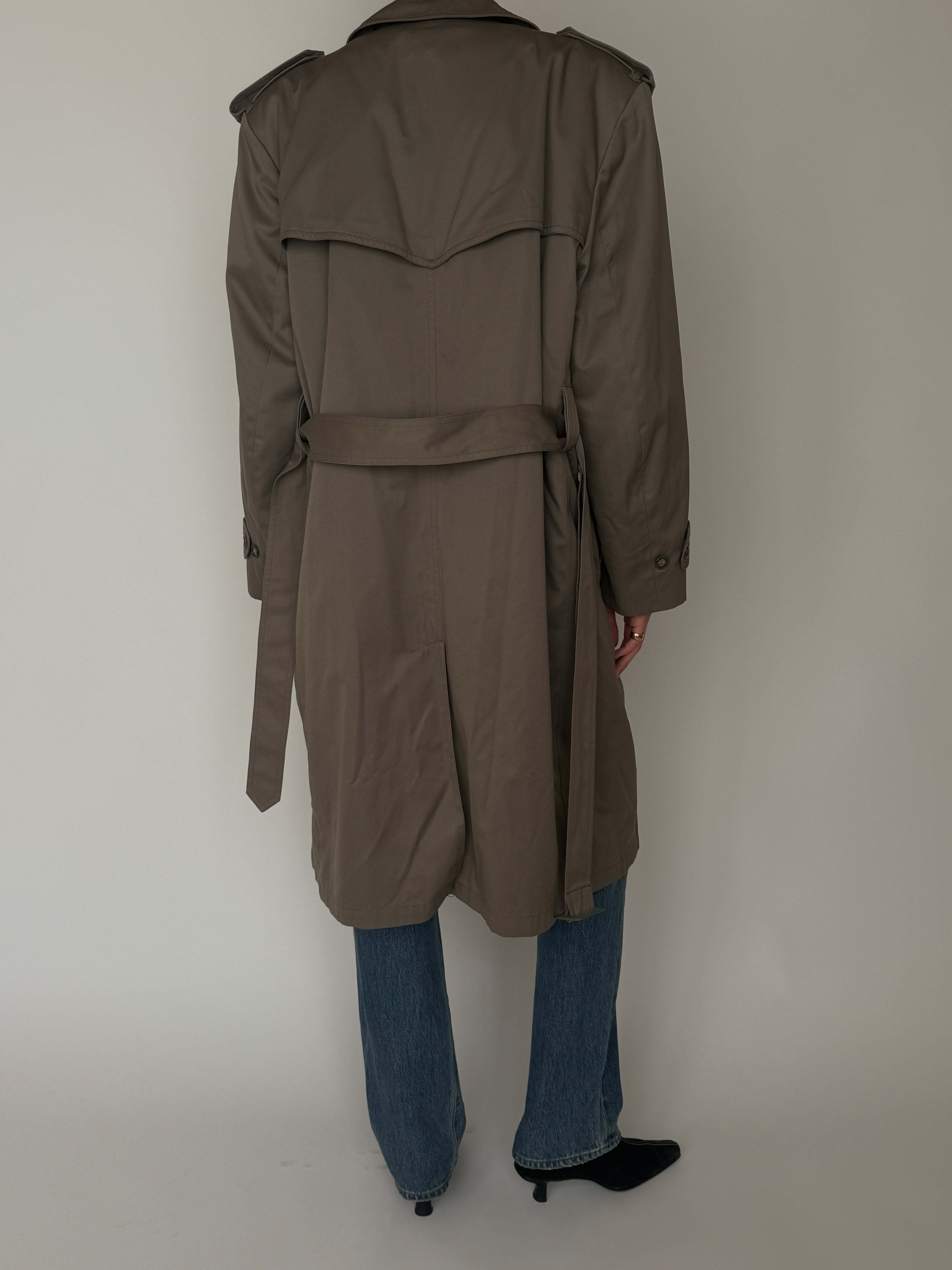 Back view of vintage trench coat with storm flap detail