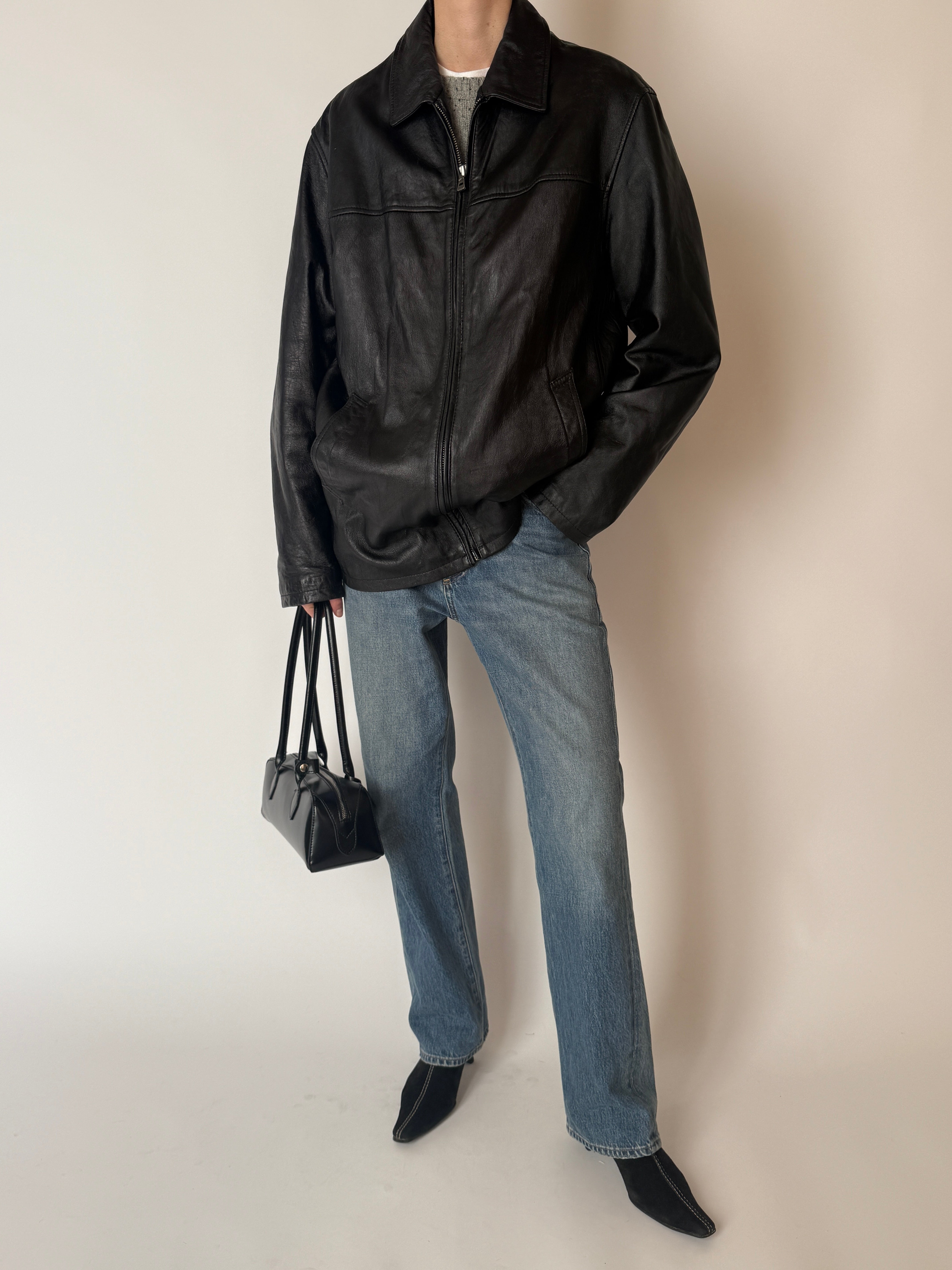 Vintage black leather jacket showing back view and seam detailing