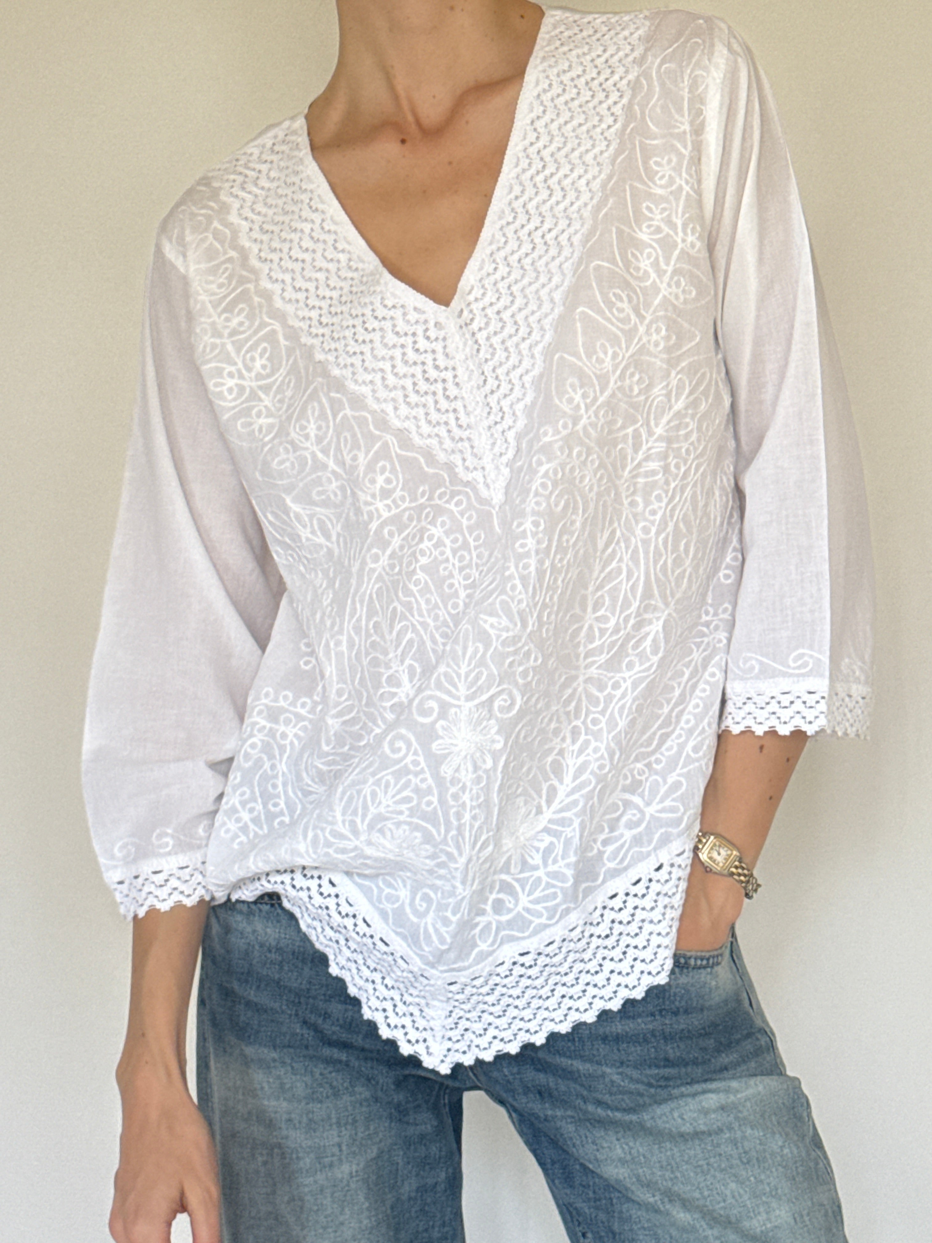 Vintage white embroidered cotton blouse close-up of floral embroidery