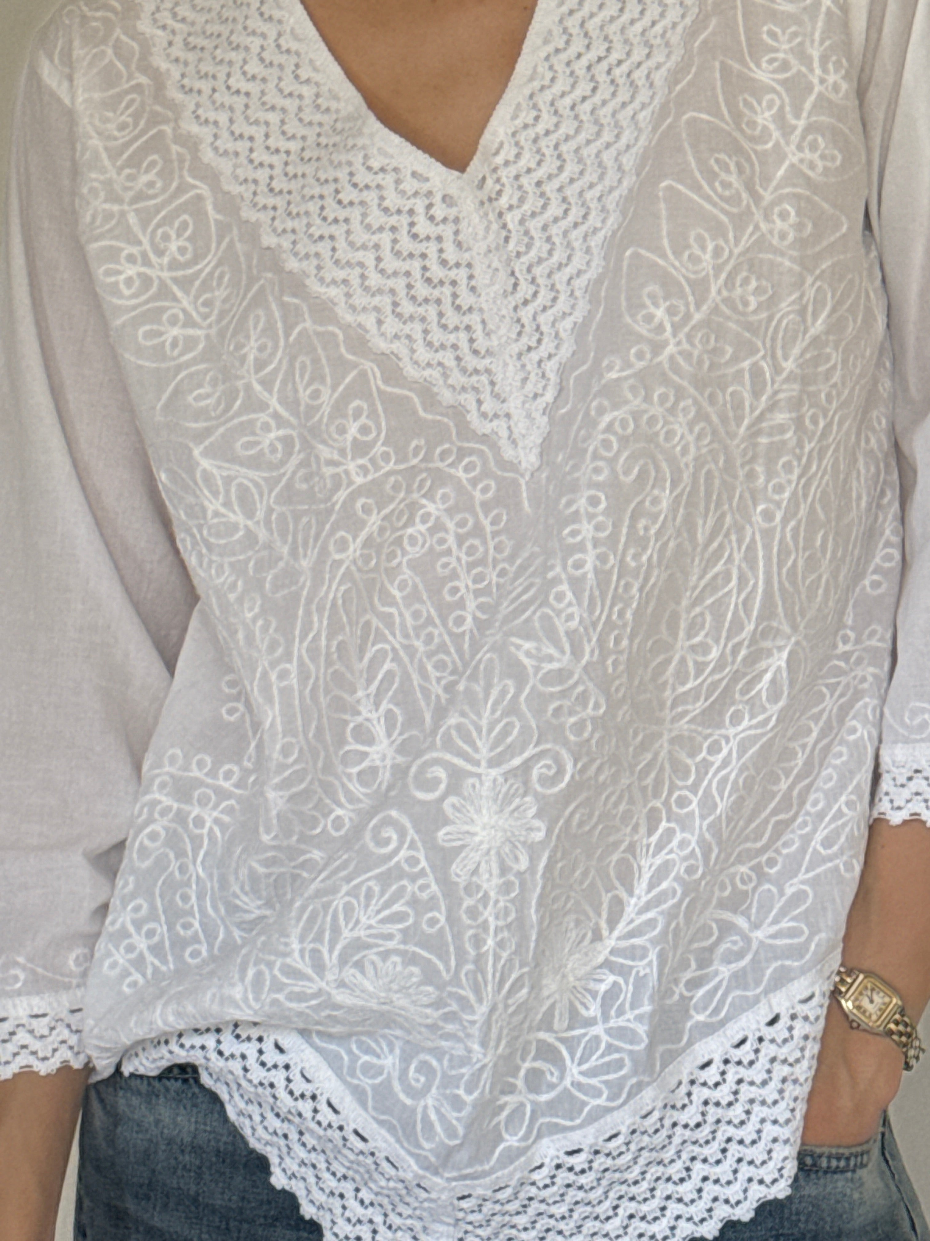 Vintage white embroidered cotton blouse close-up of floral embroidery