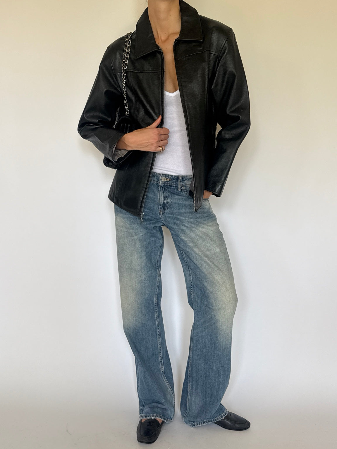 Black leather jacket styled with jeans, full-length front view