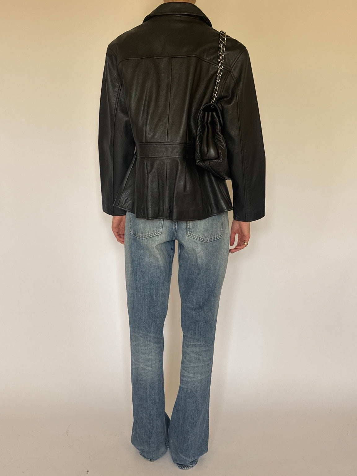Black leather jacket styled with jeans, full-length back view