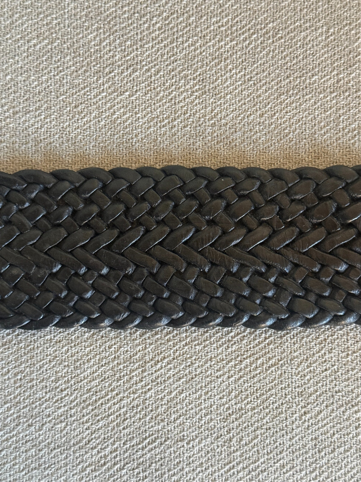 Black braided leather belt and oversized round hammered silver-tone buckle
