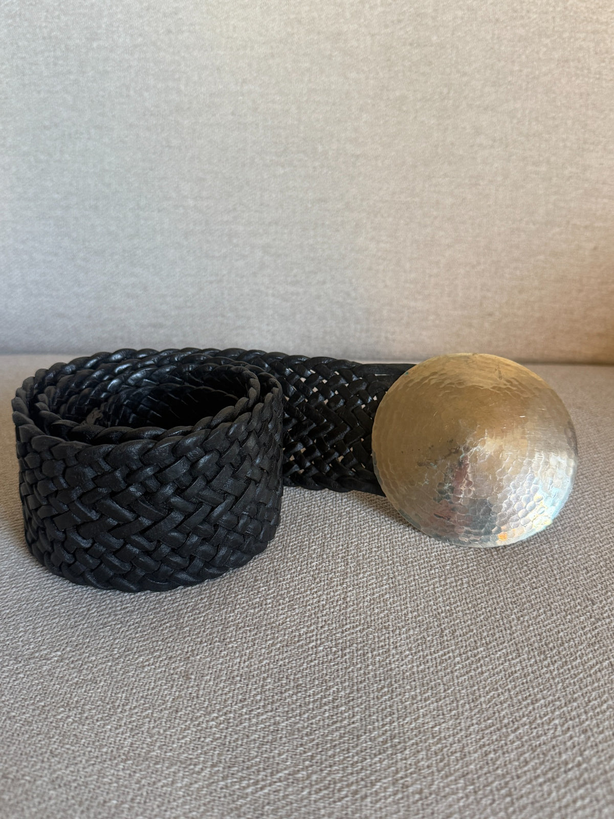 Black braided leather belt and oversized round hammered silver-tone buckle