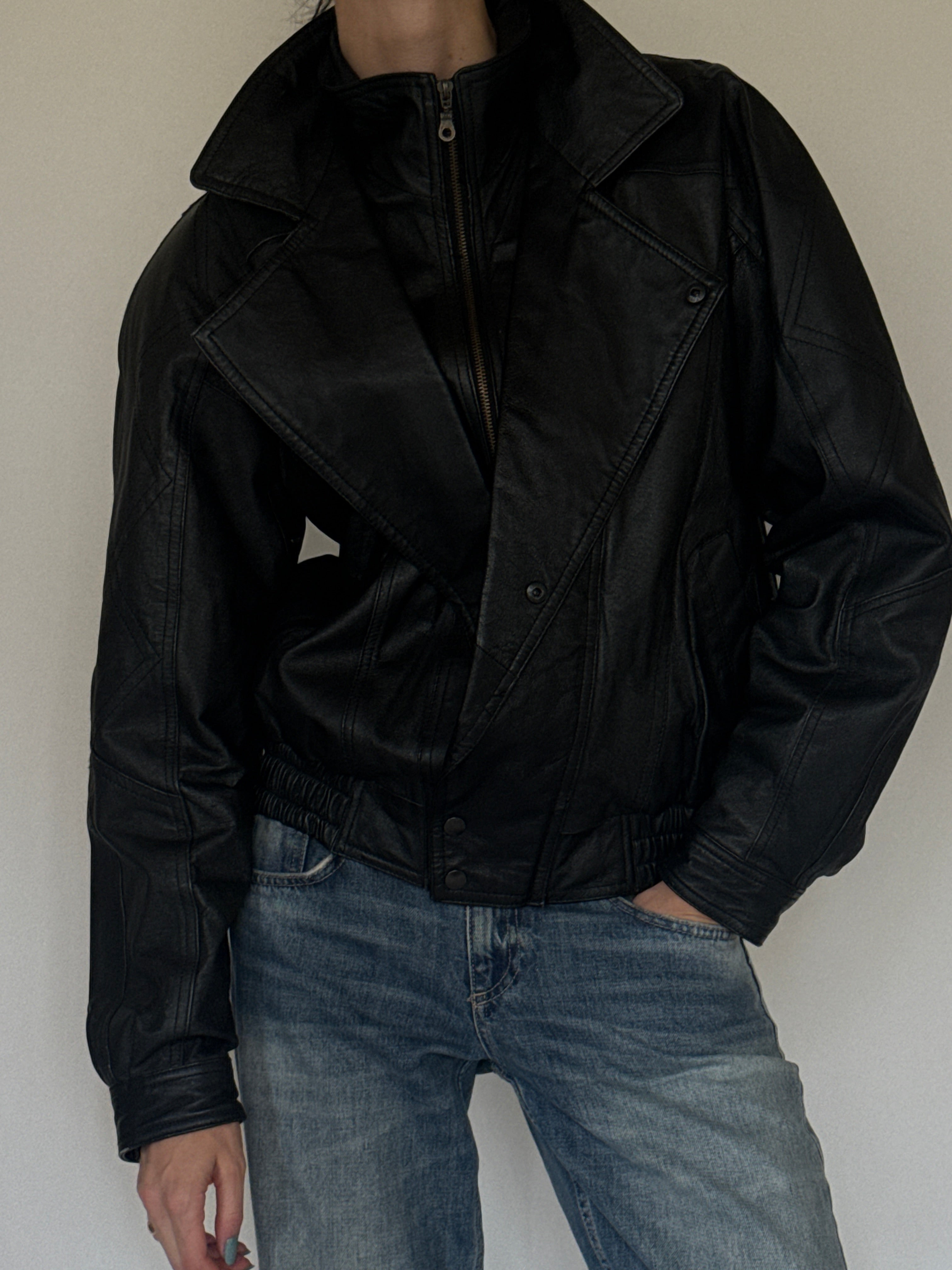 Vintage oversized black leather bomber jacket leather texture close-up