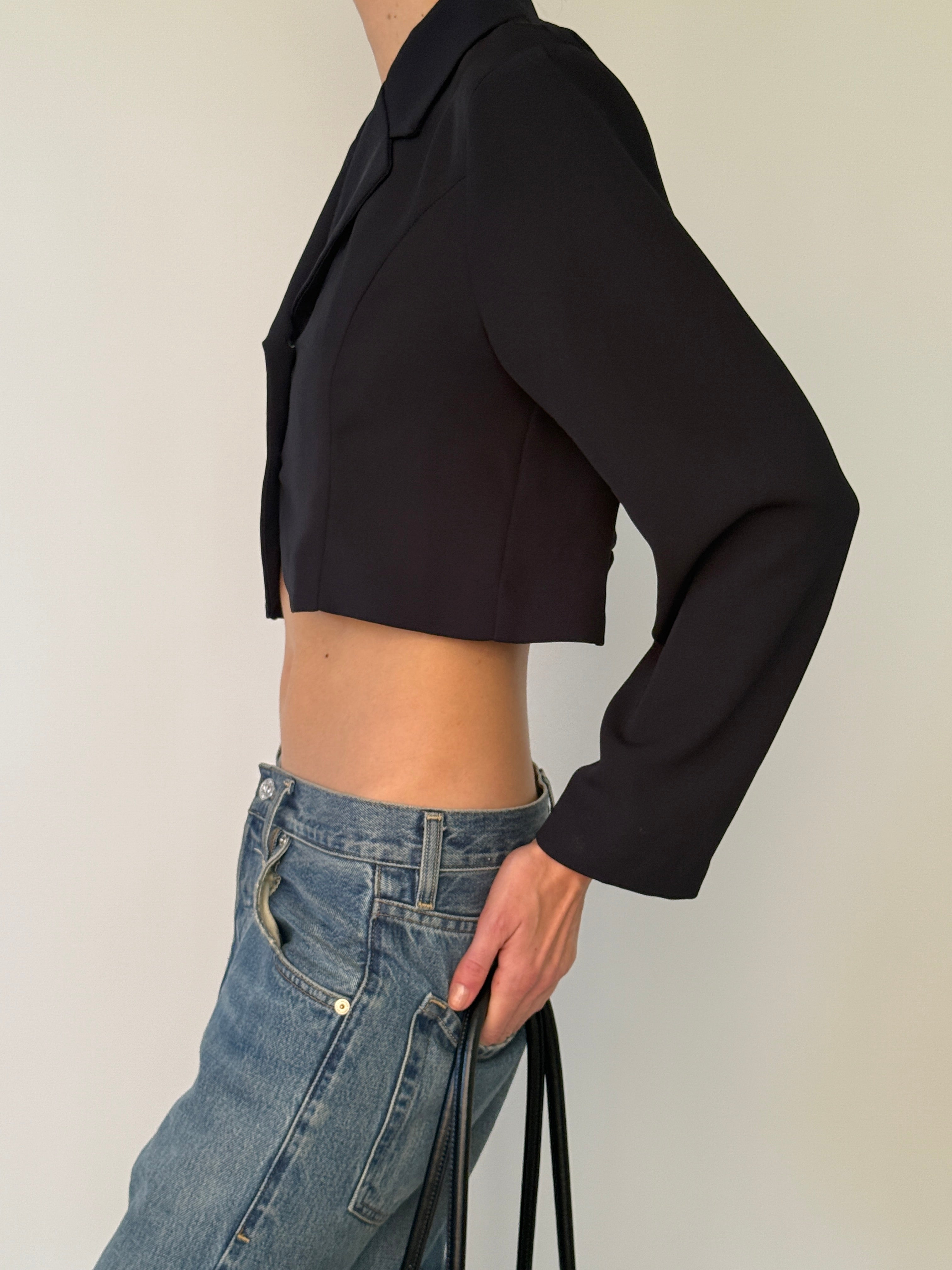 Vintage black cropped blazer with curved front hem and clean minimalist finish side view