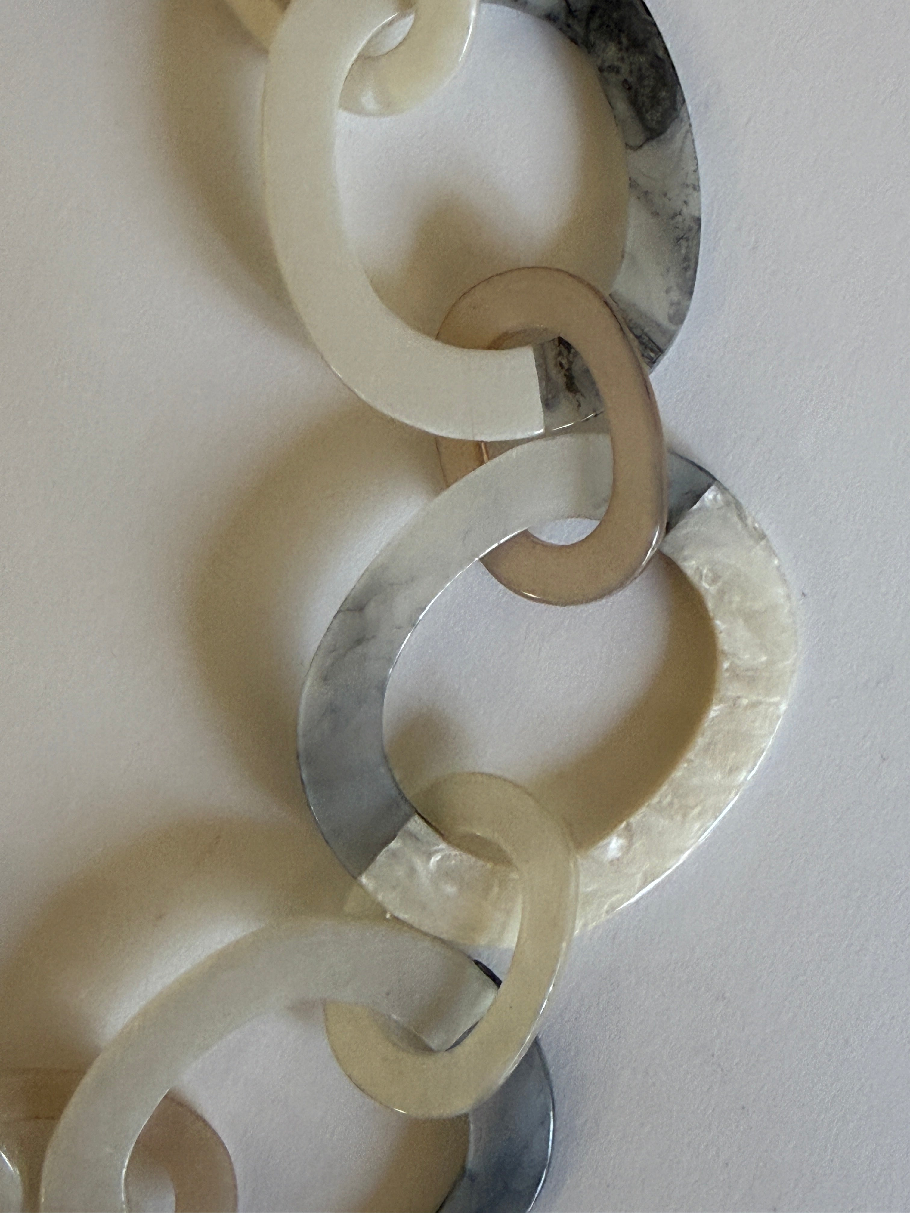 Vintage pearl-effect resin links close-up