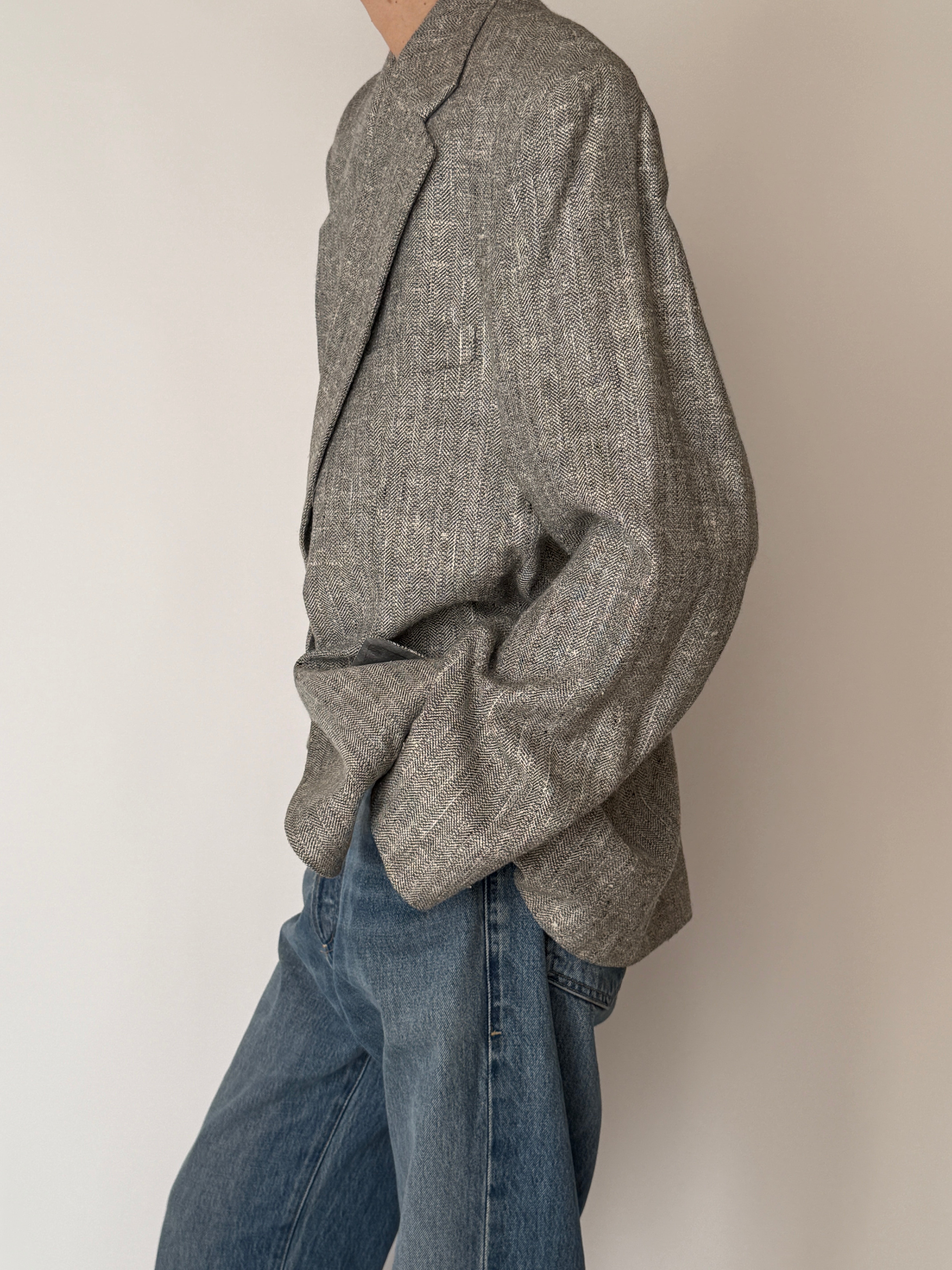 Vintage grey herringbone blazer sleeve texture close-up
