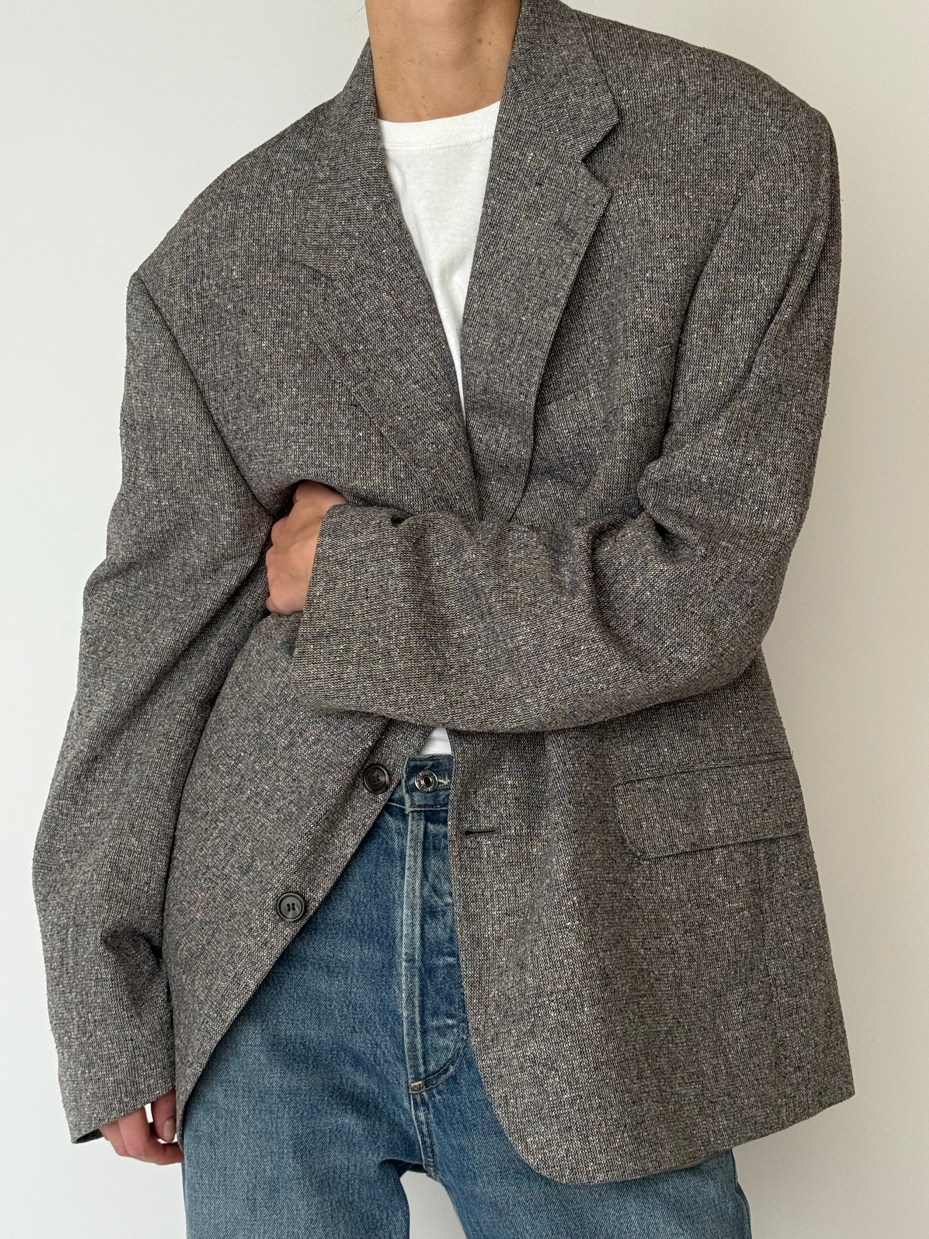 Vintage silk blazer featuring relaxed oversized fit and front button closure in brown close-up