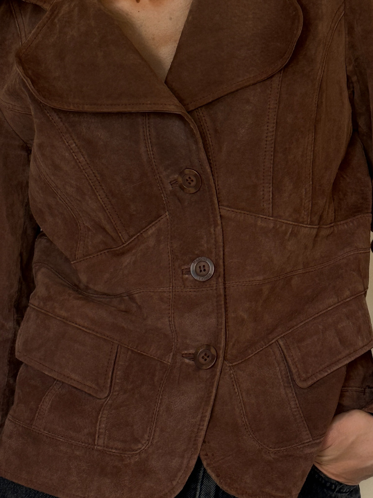Three-button closure of vintage brown suede leather jacket
