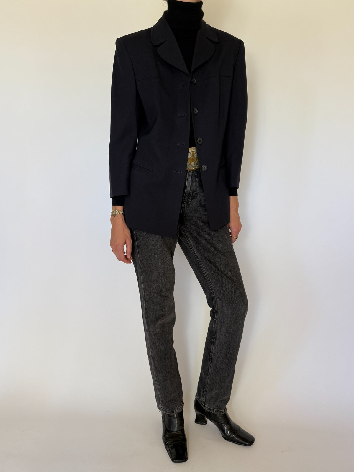 Three-quarter view of navy blazer with dark denim