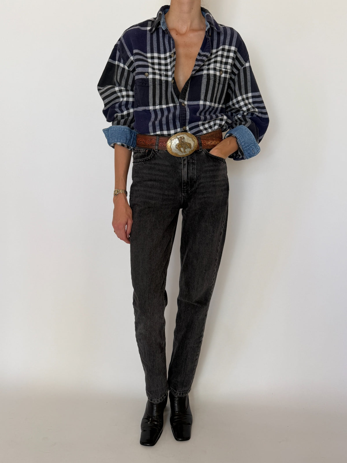 Side view of vintage navy plaid flannel shirt styled tucked into jeans