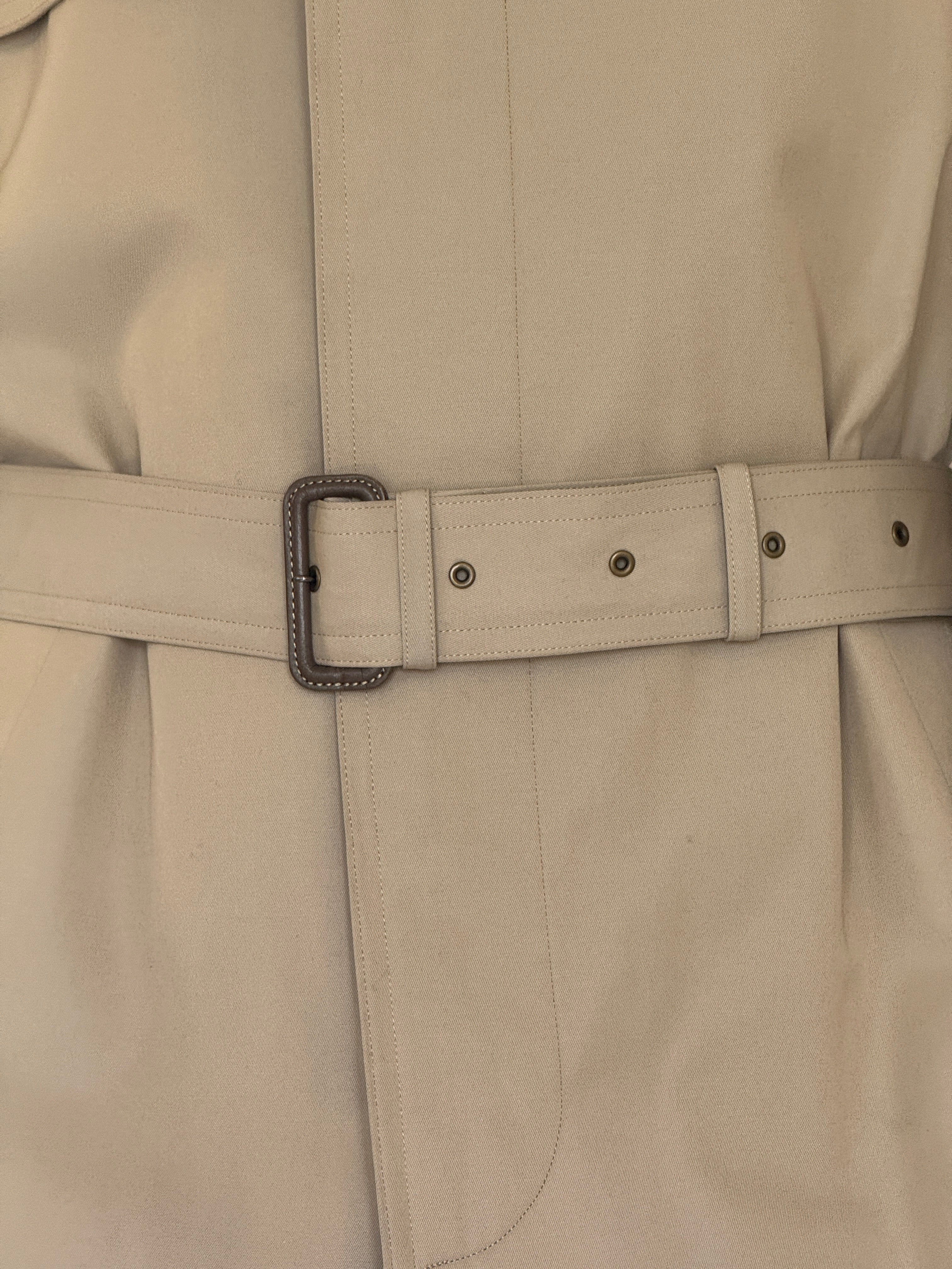 Vintage beige trench coat belt buckle detail close-up