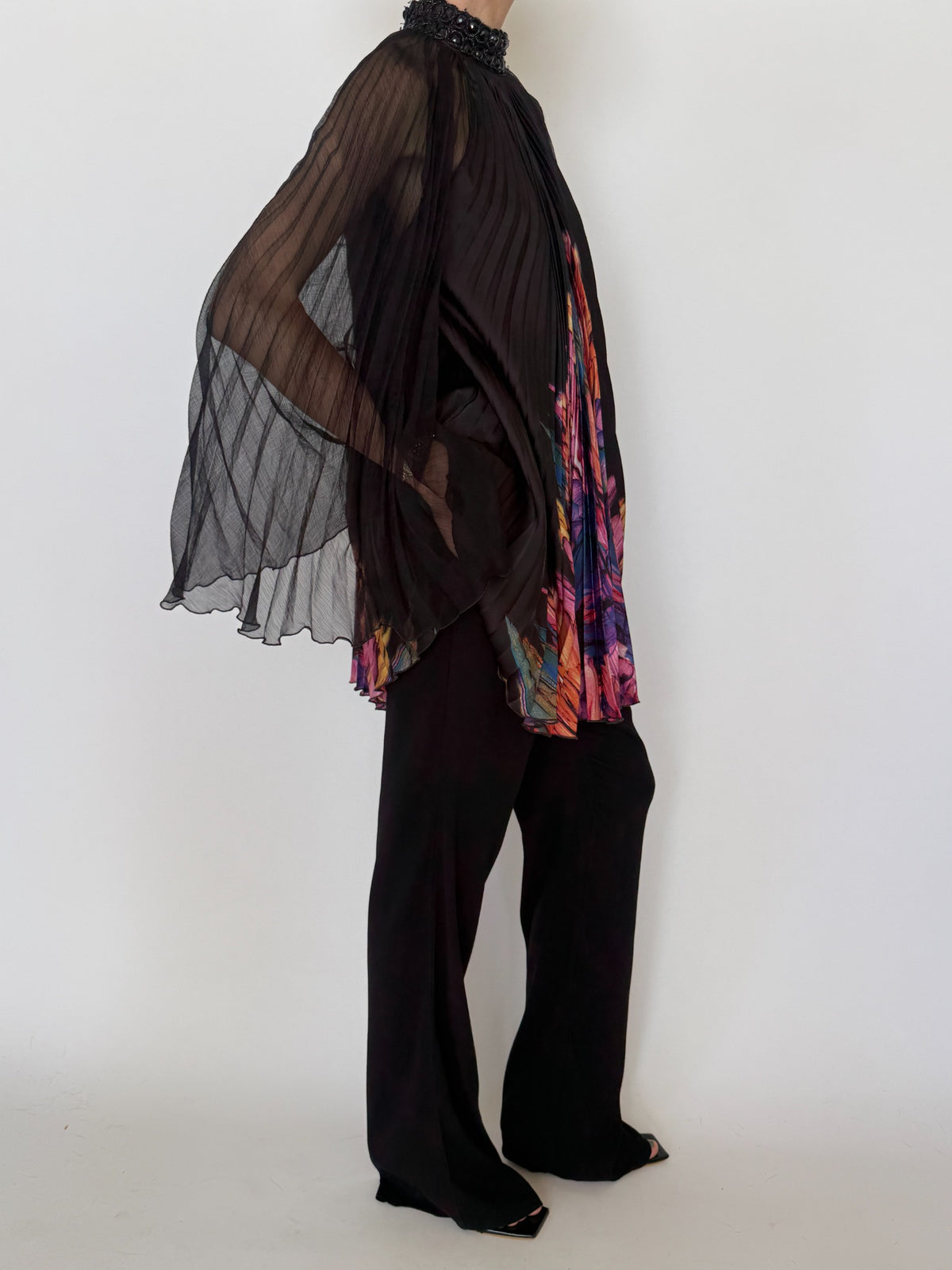 Side view of black sheer cape sleeve pleated tunic