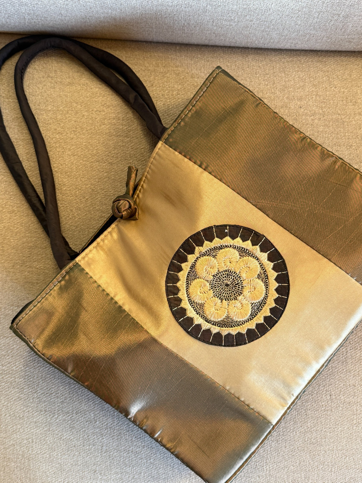 Angled view of gold and bronze color-block tote bag
