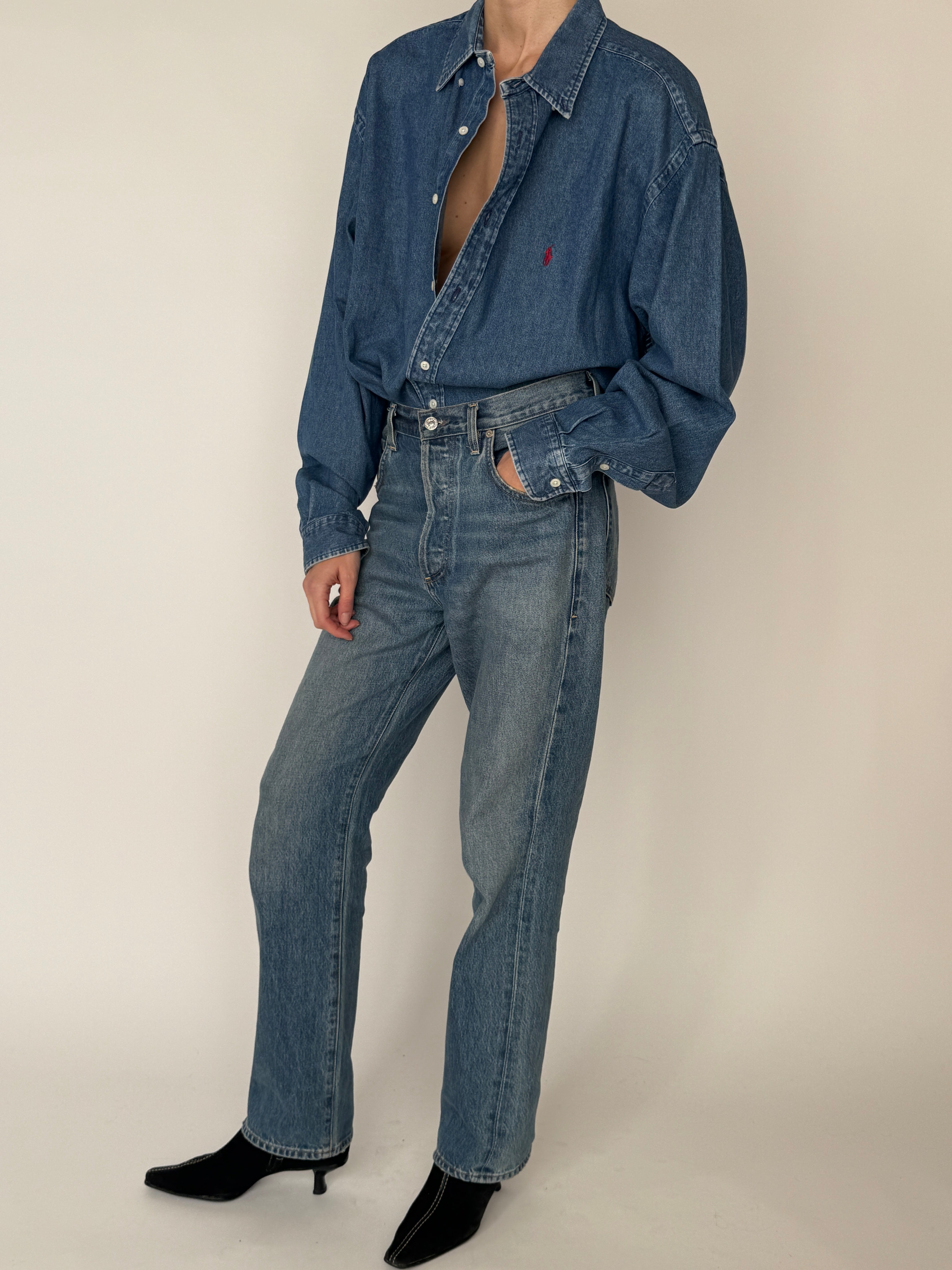 Vintage denim button-down shirt with relaxed fit and embroidered logo in blue styled