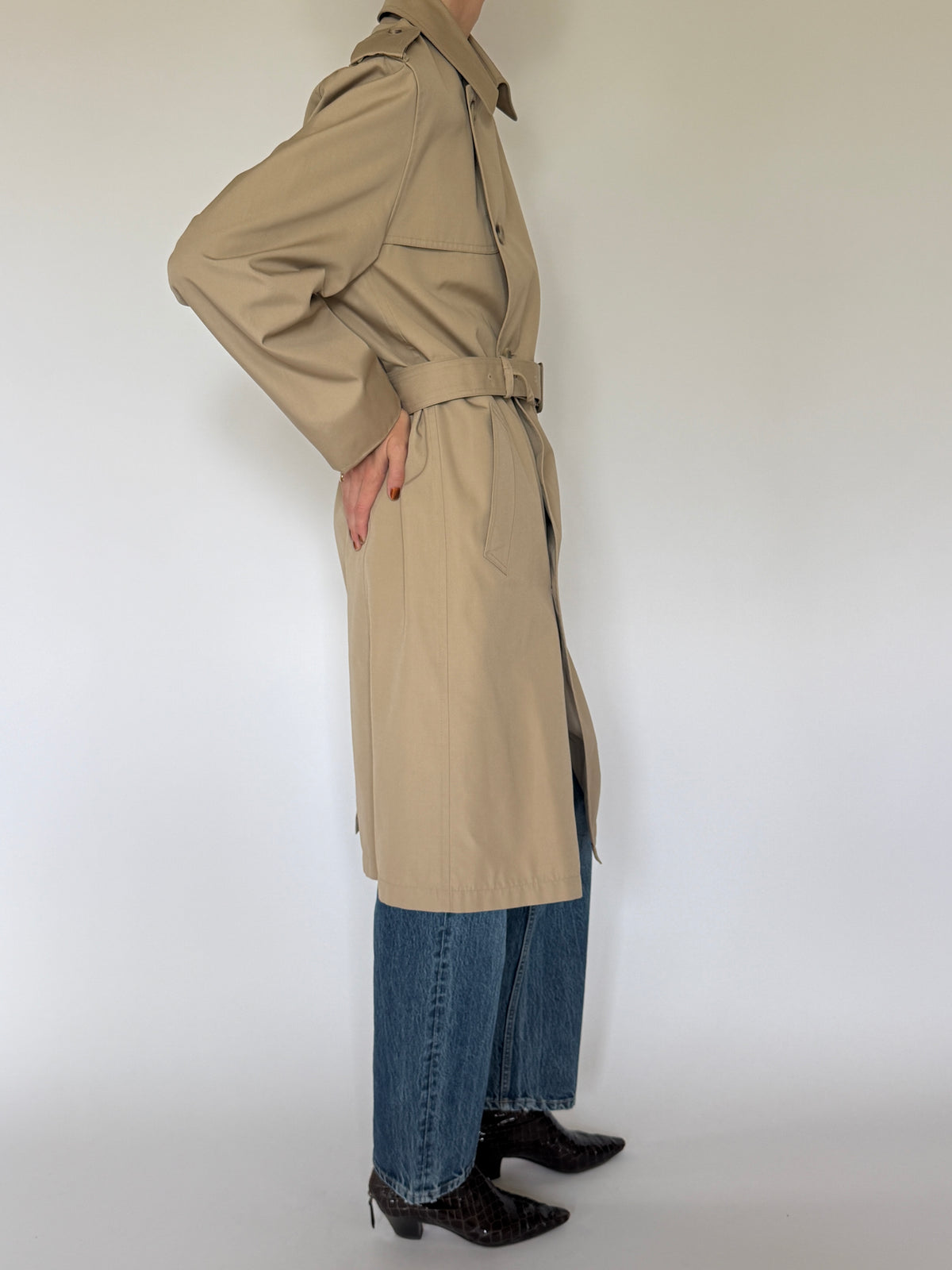 Vintage tan trench coat side view showing long silhouette and angled pocket