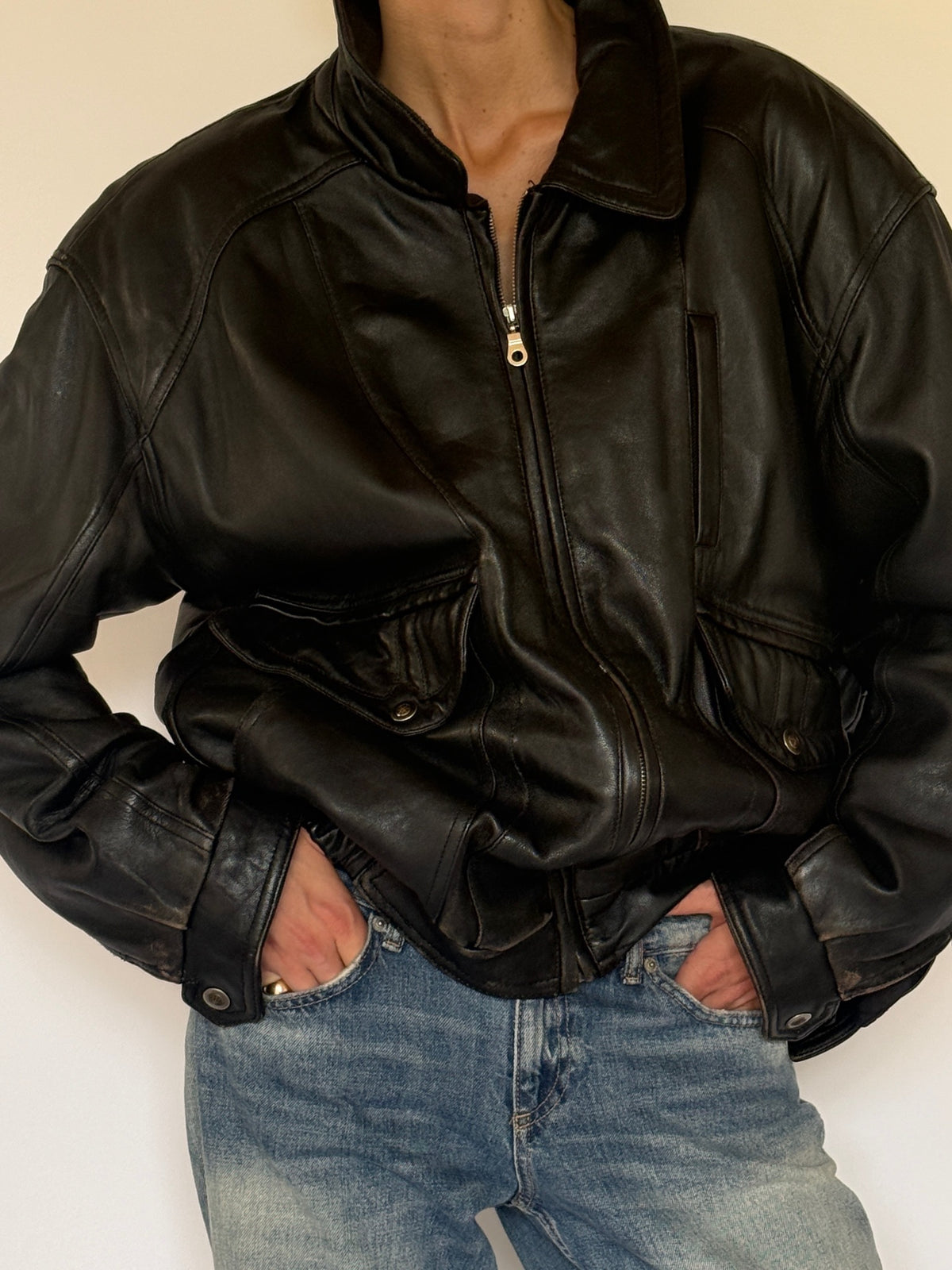 Vintage black leather bomber jacket collar and pocket detail