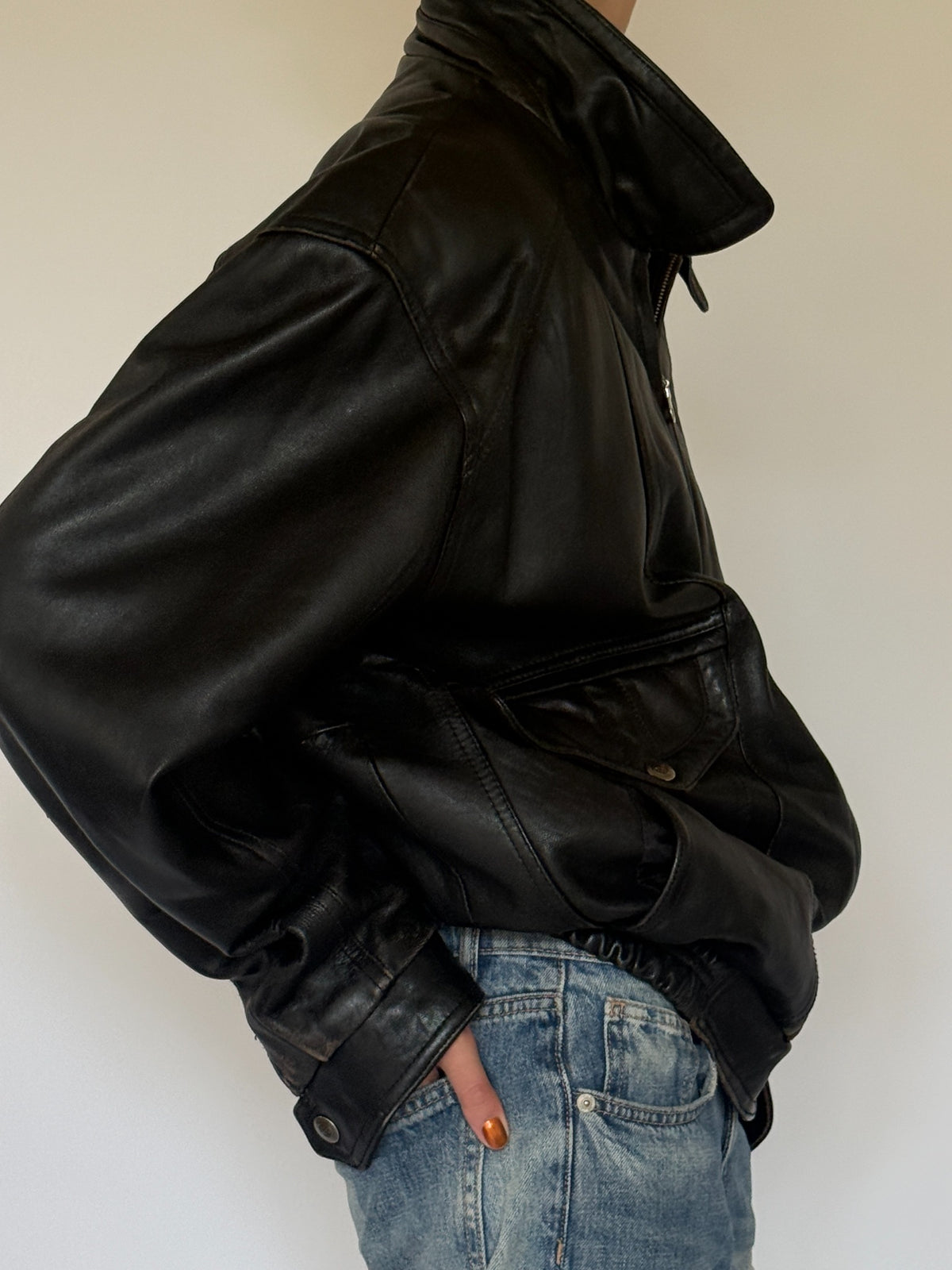 Vintage black leather bomber jacket side view