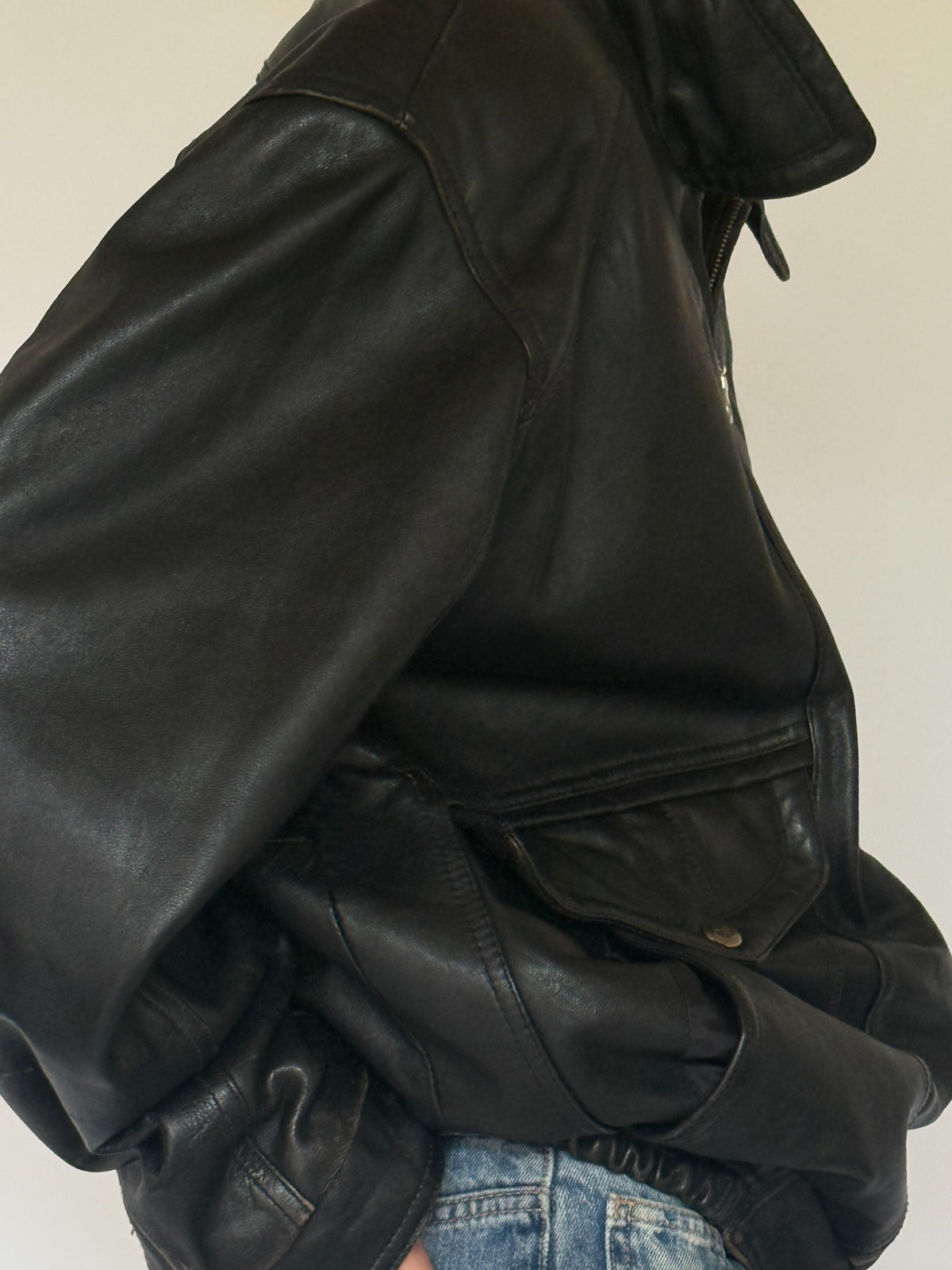 Vintage black leather bomber jacket pocket detail