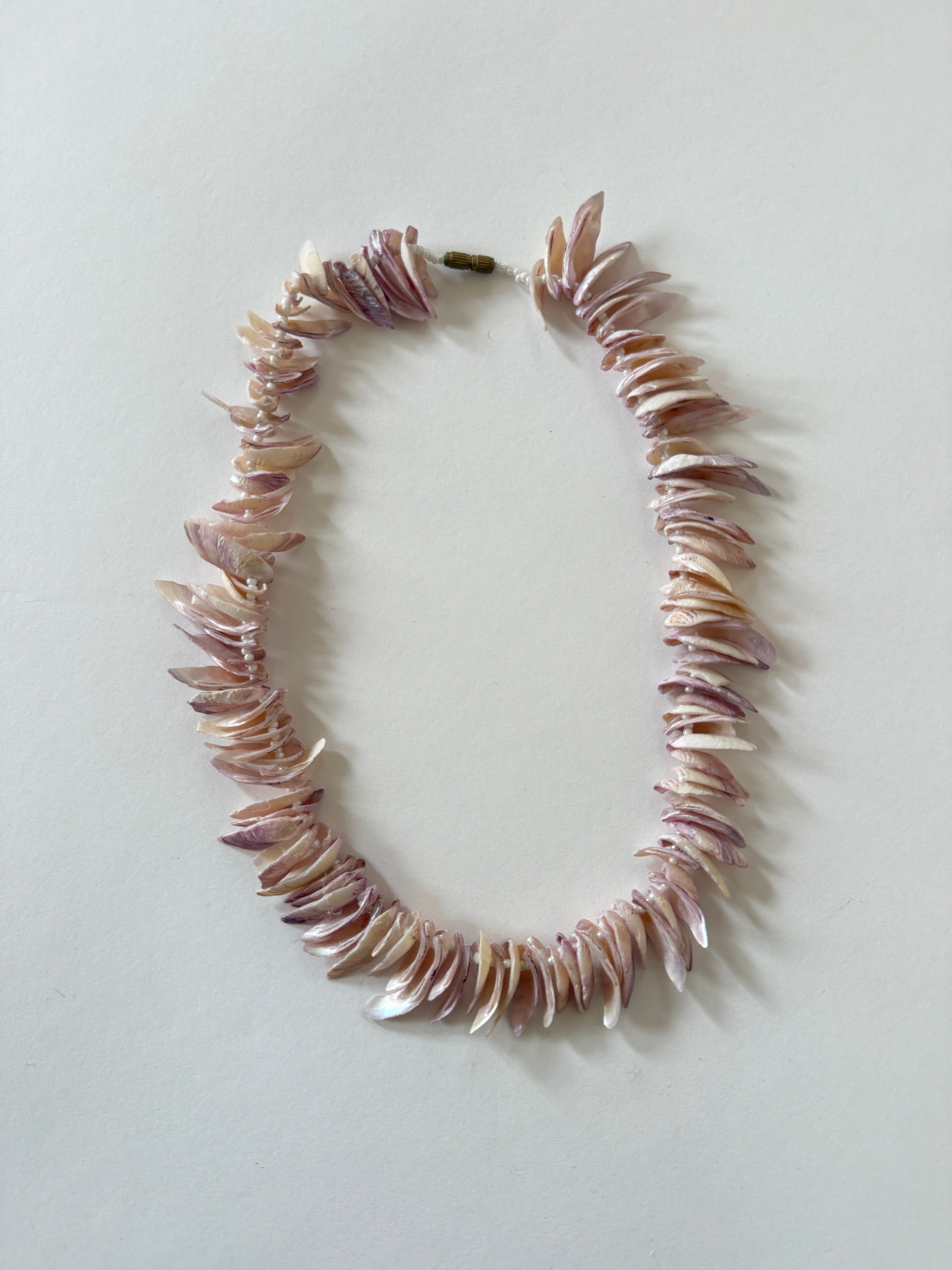 Vintage pink shell chip necklace angled side view showing strand texture