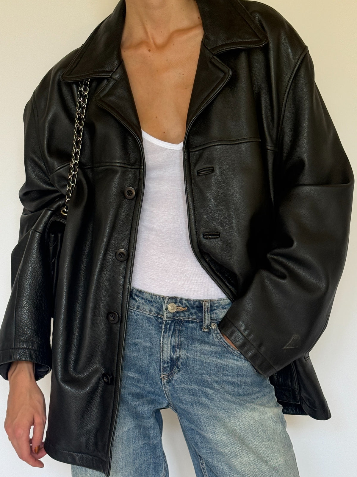 Vintage black leather jacket button and pocket detail