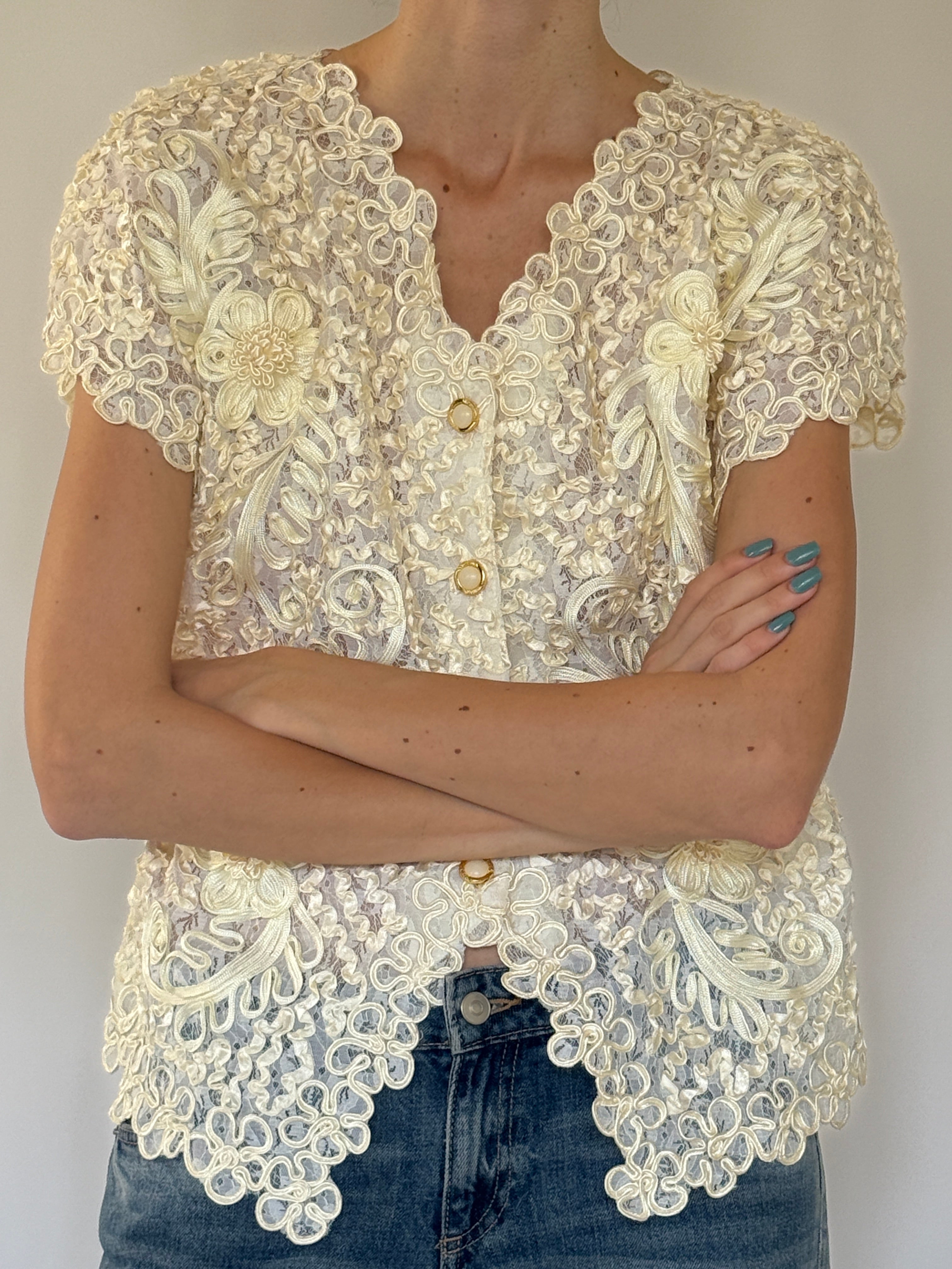 Vintage cream lace floral top close-up of gold-tone button front closure
Vintage cream lace floral top close-up of embroidered floral appliqué detail