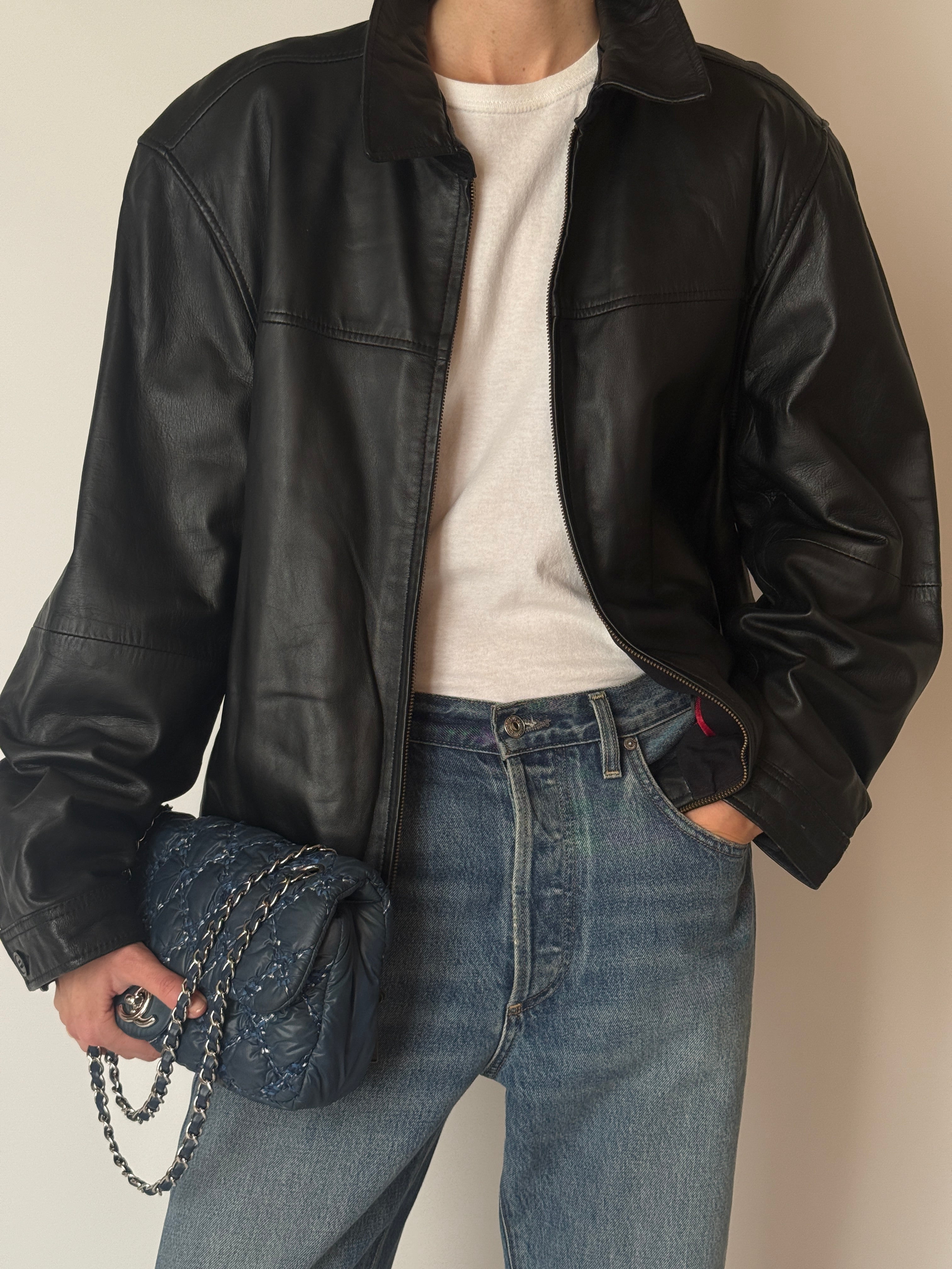 Vintage black leather jacket with subtle worn-in patina and soft finish