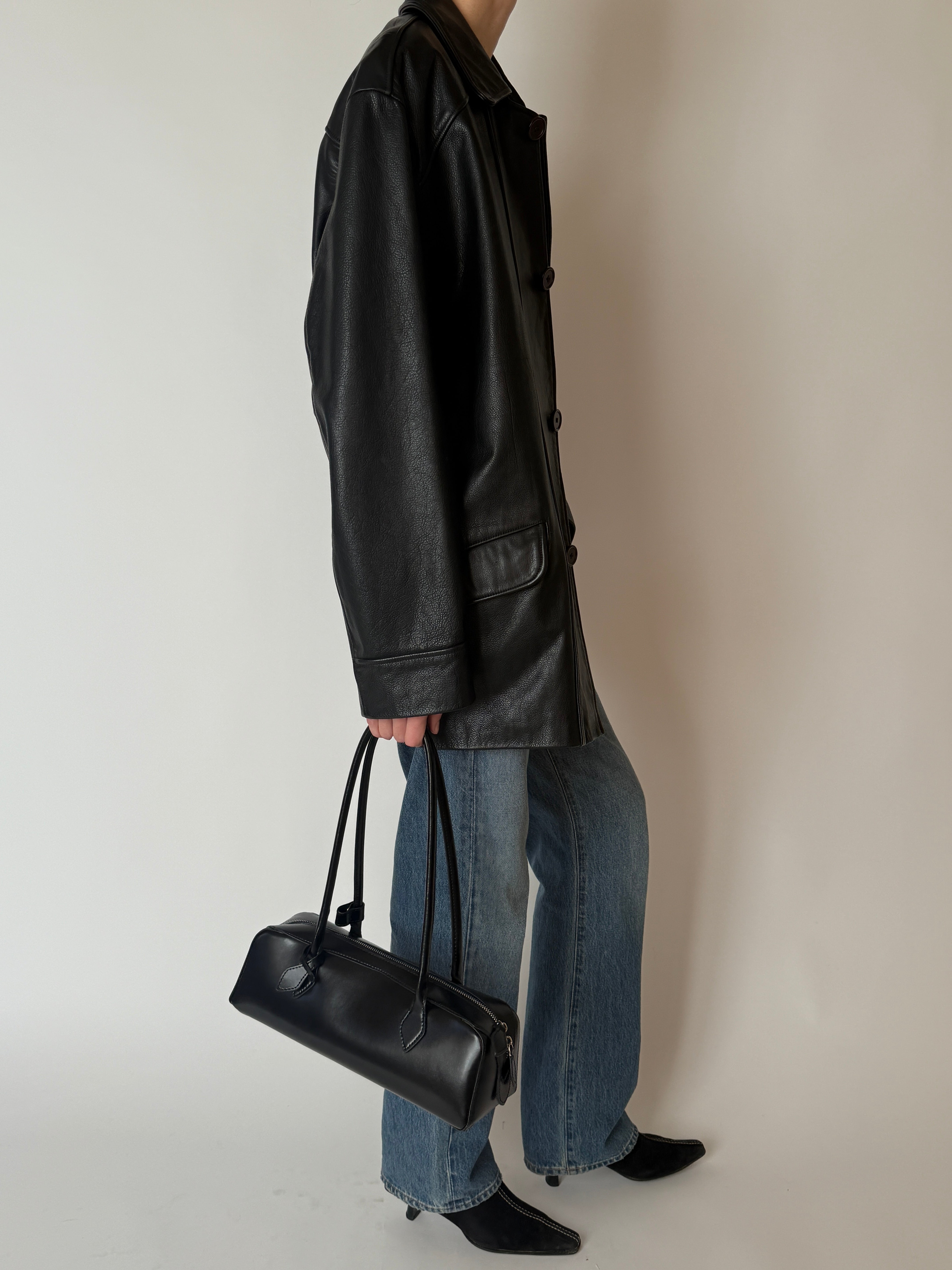 Vintage black leather jacket with soft patina and front pockets side view