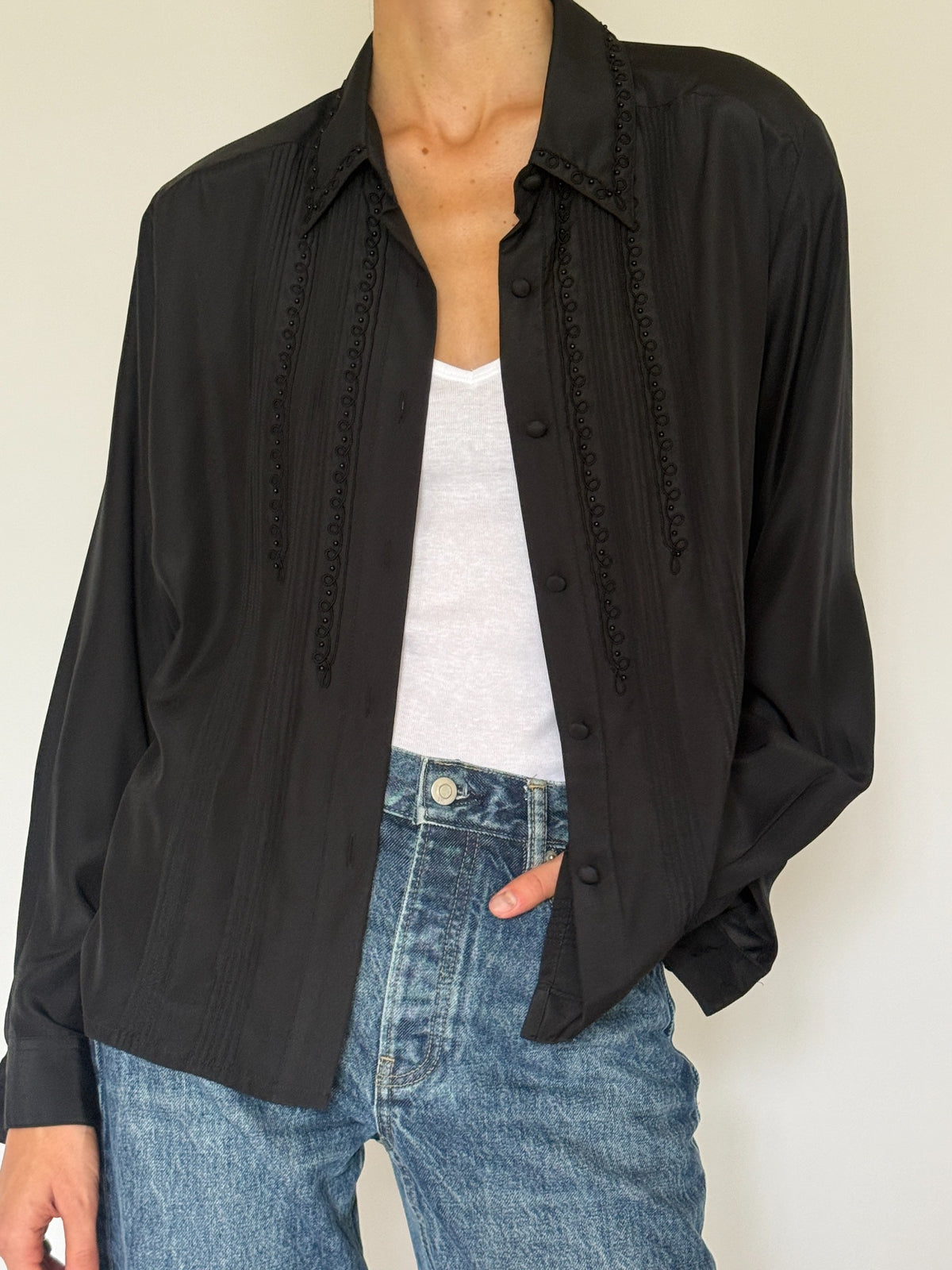 Front detail of black blouse embroidery and buttons